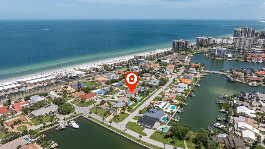 Built in 2021, this modern Mediterranean villa style home with partial views of the intercoastal is located in the beautiful community of Belleair Beach. This home not only has the advantages of being a newer home built with spectacular architectural detail and is also elevated above the flood plain. A short walk to the beach, the house is located on a quiet side street on an oversized lot complete with new vinyl fencing that offers privacy. It also provides enough room to let your pets roam around! A large, gas heated pool and spa with a built-in sundeck were added in 2022.  This outstanding home with camera system and electronic keypad has everything you could expect in a dwelling of this caliber. The stairs or the elevator take you to an open split floor plan which features 4 bedrooms, 3.5 baths all designer inspired, an open spacious downstairs family room with a 2-story soaring coffered ceiling for a dramatic spacious effect, a loft area on the third floor serves the upstairs 3 bedrooms as extra living space for family and guests. The fresco balcony space with its designer railing add to the impact of the overall contemporary design. The modern kitchen is spacious and flows off the downstairs living area for entertaining, the large center island with extra sitting, ample quartz countertops, Viking stainless steel appliances, generous custom coastal style cabinetry, built in oven and microwave, gas stove with custom range hood all make this kitchen a chef's delight and a center pointe for get togethers.  There are two ensuite bedrooms, the one on the second level is the primary with custom walk-in shower and garden tub. Other features of this home include custom window treatments, an oversized garage with epoxy finish flooring and enough space for all the toys and even an extra workshop space. In 2025, an AC system was added to the garage area and also a generator to serve the entire house in case of temporary loss of electricity. There are two zone high efficiency heat pump air conditioners, Pella impact windows and doors throughout, professional landscaping with fruit trees and auto sprinkler system. Located minutes from shopping, restaurants and famous Clearwater Beach, this is a complete package on a hardly lived in newer home that you don't want to miss. Upfront disclosure: the property had minimum water intrusion in the garage area during the devastating 2024 Hurricane Helene.  Both cars in the garage at the time were not affected and there was no need for a flood claim.