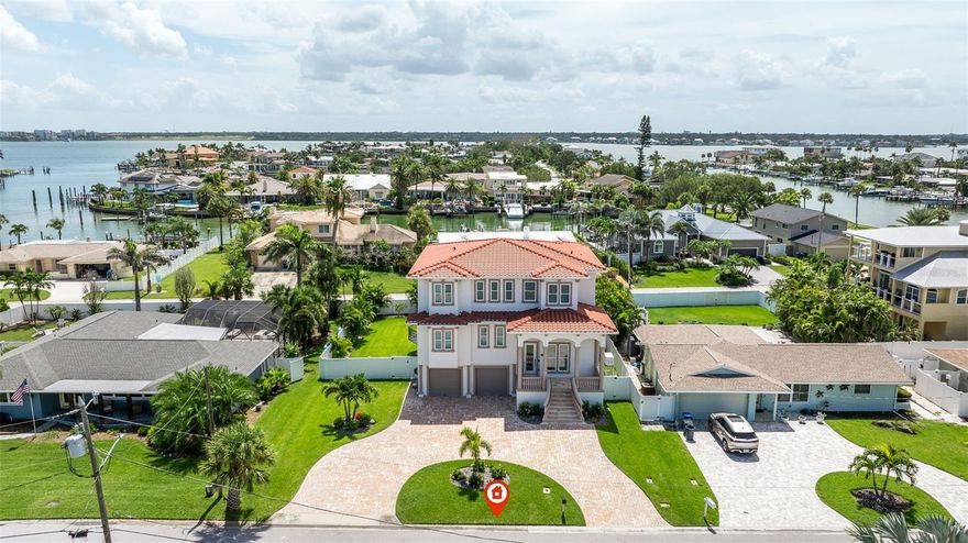 Built in 2021, this modern Mediterranean villa style home with partial views of the intercoastal is located in the beautiful community of Belleair Beach. This home not only has the advantages of being a newer home built with spectacular architectural detail and is also elevated above the flood plain. A short walk to the beach, the house is located on a quiet side street on an oversized lot complete with new vinyl fencing that offers privacy. It also provides enough room to let your pets roam around! A large, gas heated pool and spa with a built-in sundeck were added in 2022.  This outstanding home with camera system and electronic keypad has everything you could expect in a dwelling of this caliber. The stairs or the elevator take you to an open split floor plan which features 4 bedrooms, 3.5 baths all designer inspired, an open spacious downstairs family room with a 2-story soaring coffered ceiling for a dramatic spacious effect, a loft area on the third floor serves the upstairs 3 bedrooms as extra living space for family and guests. The fresco balcony space with its designer railing add to the impact of the overall contemporary design. The modern kitchen is spacious and flows off the downstairs living area for entertaining, the large center island with extra sitting, ample quartz countertops, Viking stainless steel appliances, generous custom coastal style cabinetry, built in oven and microwave, gas stove with custom range hood all make this kitchen a chef's delight and a center pointe for get togethers.  There are two ensuite bedrooms, the one on the second level is the primary with custom walk-in shower and garden tub. Other features of this home include custom window treatments, an oversized garage with epoxy finish flooring and enough space for all the toys and even an extra workshop space. In 2025, an AC system was added to the garage area and also a generator to serve the entire house in case of temporary loss of electricity. There are two zone high efficiency heat pump air conditioners, Pella impact windows and doors throughout, professional landscaping with fruit trees and auto sprinkler system. Located minutes from shopping, restaurants and famous Clearwater Beach, this is a complete package on a hardly lived in newer home that you don't want to miss. Upfront disclosure: the property had minimum water intrusion in the garage area during the devastating 2024 Hurricane Helene.  Both cars in the garage at the time were not affected and there was no need for a flood claim.