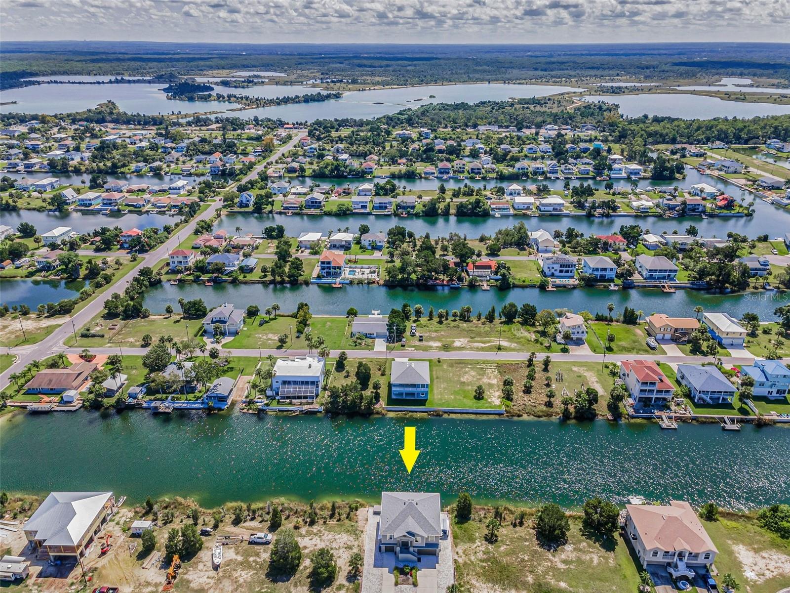 Your Dream Home is Ready Now! Stunning 2023 built Palmwood waterfront custom home in the quaint coastal community of Hernando Beach, featuring an elevator, expansive outdoor kitchen/bar and exceptional entertaining spaces. Curb appeal shines with paver walkways, tiled stairway and steel double-door entry. Inside, plank-style tile, impact windows/doors and a 10’ tray-ceiling great room with electric fireplace create a modern, light-filled space. Chef’s Kitchen boasts island seating, navy/gray Sonoma cabinetry with soft-close pull-outs, granite counters, subway tile backsplash, and premium KitchenAid black stainless appliances, plus a built-in Wolf coffee/espresso maker. Dining area offers panoramic canal views, motorized sheer shades and sunrise vistas. Private Primary Suite features motorized shades, a walk-in closet with custom cabinetry built by "Create More Space", and spa-style bath with soaking tub, stone wall shower and maple cabinetry with granite counters. Two guest bedrooms include one with custom cabinetry, desk, Murphy bed and worktables. Garage/man cave and optional 4th bedroom (with AC) on lower level. Outdoor extras include a golf cart/carport, large storage unit and a full outdoor kitchen/bar with pizza oven, gas grill, griddle, sink, wood ceiling, fans and heaters. Composite dock with step-down boat access, upper deck and Caldera saltwater spa to relax and enjoy. Additional upgrades include two motorized awnings, EV charger and transferable builder warranty. Golf cart-friendly, waterfront community with no HOA or CDD fees, where you can just sit back and enjoy boating, fishing and amazing Gulf sunsets!