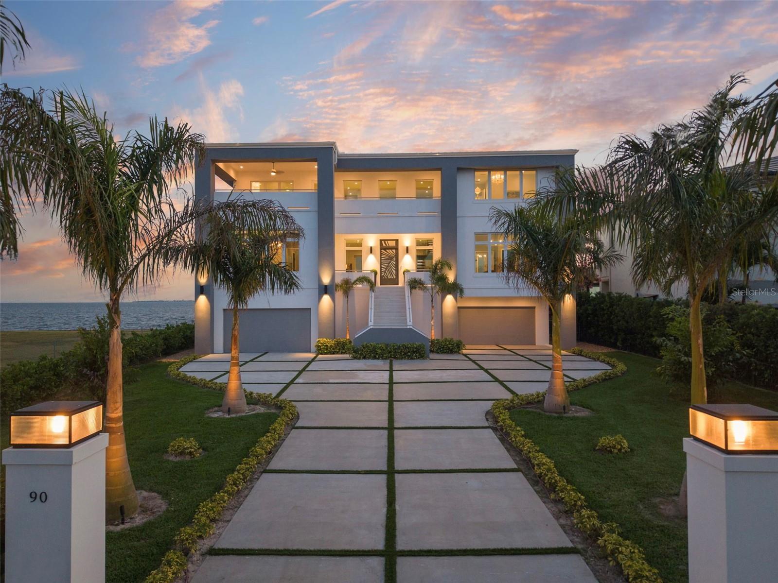 Introducing Oceara, a landmark of bold design, superior engineering and refined coastal living on Tampa’s prestigious Billionaires Row in Davis Islands. Built by renowned Alvarez Homes and completed in late 2024, this architectural fortress is constructed of poured concrete and steel, elevated to meet FEMA codes, anchored by 40-foot-deep pilings driven to bedrock, and topped with a riveted metal roof and full-impact glass throughout. Go inside to a grand double-height foyer, grounded in architectural sophistication, with a floating glass-and-metal staircase revealing uninterrupted water views of Tampa Bay. Oceara features six luxurious private suites, a game room, elevator, and an expansive garage accommodating eight or more vehicles. Designed to embody enduring strength and contemporary design, the home offers oversized covered balconies that invite year-round enjoyment of outdoor living in the gentle coastal breeze. Set on Davis Islands, a self-contained island offering everyday essentials, charming cafes and home to Tampa General Hospital. This golf cart community also features a marina, beach, dog park and convenient access to the nearby Davis Islands Airport. Just minutes from downtown Tampa, Oceara combines ultimate luxury with rare accessibility. The resort-style pool, like the home itself, is supported by deep pilings for lasting peace of mind. From sunrise to sunset, Oceara redefines elevated waterfront living. This home is one of one, like you. Make it yours. Sold furnished. Over 12,000 SqFt under roof, including two rear covered balconies (44' x 12') and a front balcony (approx. 20' x 12'). 100+ feet of concrete seawall.
