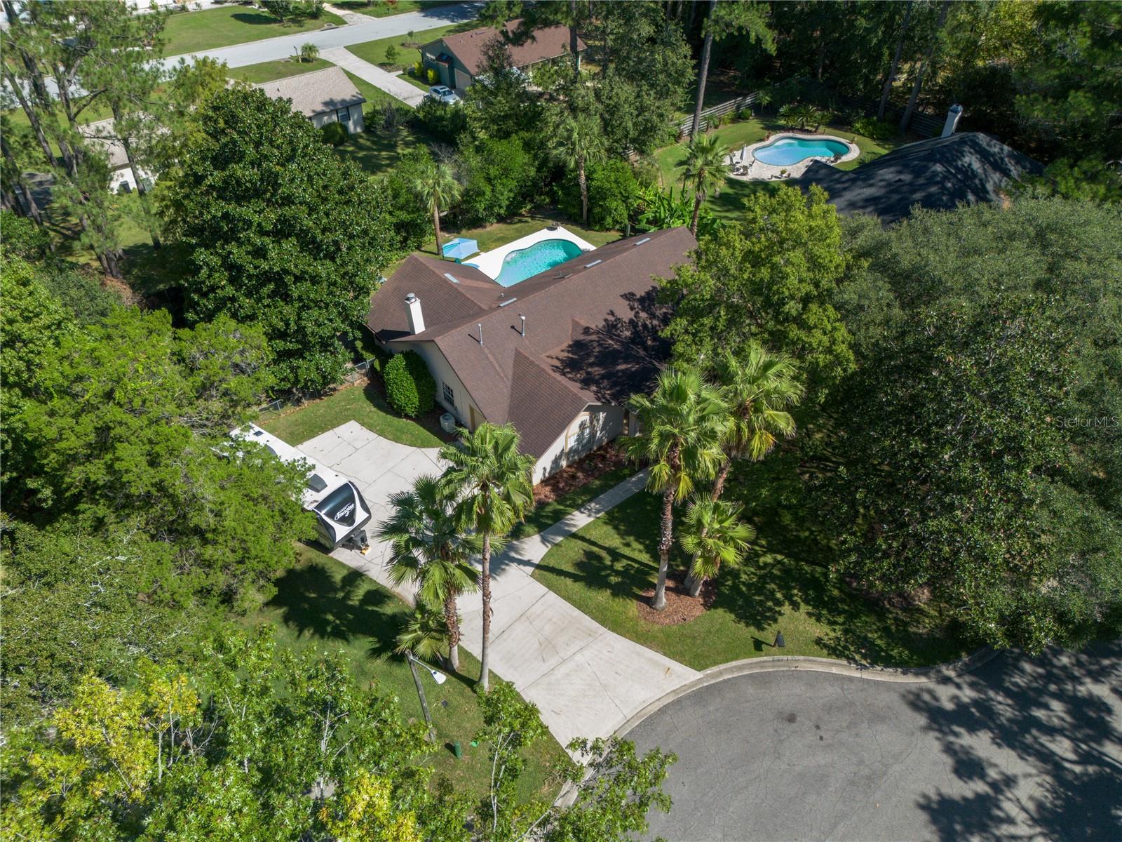 Tucked at the end of a quiet cul-de-sac in NW Gainesville's Hills of Santa Fe, this beautiful 3-bedroom, 2-bath home invites you to enjoy your own private backyard oasis—complete with a sparkling pool featuring a brand-new salt cell, filter and vacuum, a covered porch, and plenty of room to relax or entertain. Sitting on a fully fenced 0.43-acre lot, the property offers both privacy and space, with a separate fenced area perfect for pets or a garden, an extra-wide driveway ideal for parking boats or an RV, and a back gate for easy access.
Inside, you’ll find an inviting floor plan with hardwood floors, vaulted ceilings, and multiple living areas that flow easily for entertaining. The upgraded kitchen features a gas stove, new countertops and cabinets, stainless steel appliances, and a charming pool view right above the sink. The living room, anchored by a cozy fireplace, is perfect for relaxing or gathering with friends, while the formal dining room features French doors that open onto the patio and pool area for effortless indoor-outdoor living.
The primary suite includes a remodeled bath with a large tub, separate shower, and new vanity, along with a bonus room on the north side overlooking the pool—perfect for a home office, nursery, workout room, or reading nook. The split floor plan provides privacy for the guest bedrooms, and the guest bath opens directly to the pool for convenience.
Additional highlights include a 2-car side-entry garage with attic storage, a covered front entry, and a 2013 roof. With no HOA, a peaceful cul-de-sac location, and an easy, open layout designed for both comfort and entertaining, this home is a rare find that truly has it all!