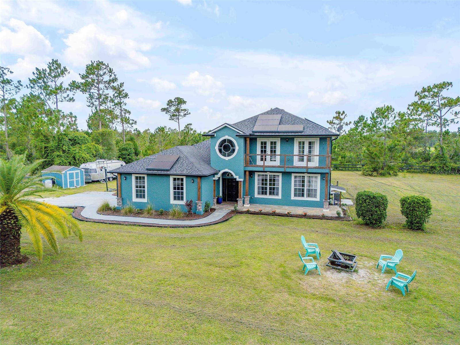 Luxurious 10.7-Acre Equestrian Estate Minutes from New Smyrna Beach! Welcome to your dream equestrian sanctuary—an exquisite 10.7-acre estate located just minutes from historic downtown New Smyrna Beach and the pristine Atlantic coastline. This rare and refined offering effortlessly blends upscale living, functional equine amenities, and serene country charm in one of Florida's most desirable coastal communities. As you pass through the private gated entrance, you're welcomed by beautifully manicured landscaping, expansive green pastures, and tranquil views framed by mature Pines. A cozy firepit graces the front yard, setting the stage for peaceful evenings under the stars. The fully fenced and multi-cross-fenced property is dry and organic—ideal for horses, agriculture, or simply enjoying a private, nature-filled retreat. The main residence, meticulously renovated and upgraded between 2022 and 2023, offers over 3,000 square feet of timeless elegance and modern sophistication. Designed for both comfort and functionality, the home includes five spacious bedrooms or flex rooms, two full bathrooms, and two half bathrooms. The heart of the home is the stunning 2023-remodeled kitchen, a chef's dream featuring custom maple wood cabinetry, Stonemark quartz countertops, a copper farmhouse sink, KUTCH gas stove, and a huge walk-in pantry. A water filter installed at the kitchen sink ensures pure, clean drinking water. The open-concept design flows seamlessly into the spacious living and dining areas, creating an inviting atmosphere perfect for everyday living and entertaining. Additional upgrades throughout the home include new luxury flooring (2023), new lighting and fans, modernized bathrooms with new toilets and faucets, and a new XL water heater (2022), whole-house water filtration system (2022), new downstairs AC unit (2022), and a new roof (2023) for added efficiency and peace of mind. Solar panels provide sustainable energy, further enhancing the property's eco-conscious appeal. Step outside to your private resort-style oasis: a fully screened, in-ground saltwater pool with ambient lighting, a peaceful waterfall, and an outdoor shower. The expansive patio area is perfect for sunbathing, relaxing, or hosting unforgettable gatheringsall surrounded by lush natural beauty and total privacy. For the equestrian enthusiast, this property delivers:
An 1,800 sq ft galvanized steel barn/stable with five custom stalls, a tack room, prep area, workshop, and ample storage.
A 13,500 sq ft paddock and 55' round pen ideal for training and turnout.
Direct access to scenic riding trails for daily adventures.
There's even space for gardening, ATV rides, or expanding your visionwhether that's multigenerational living, special events, or creating a self-sustaining retreat. Perfectly positioned just a short drive from NSB's boutiques, restaurants, art galleries, and famous beaches, this one-of-a-kind estate is more than just a homeit's a lifestyle. Private showings by appointment only. Gated access- agent must accompany.