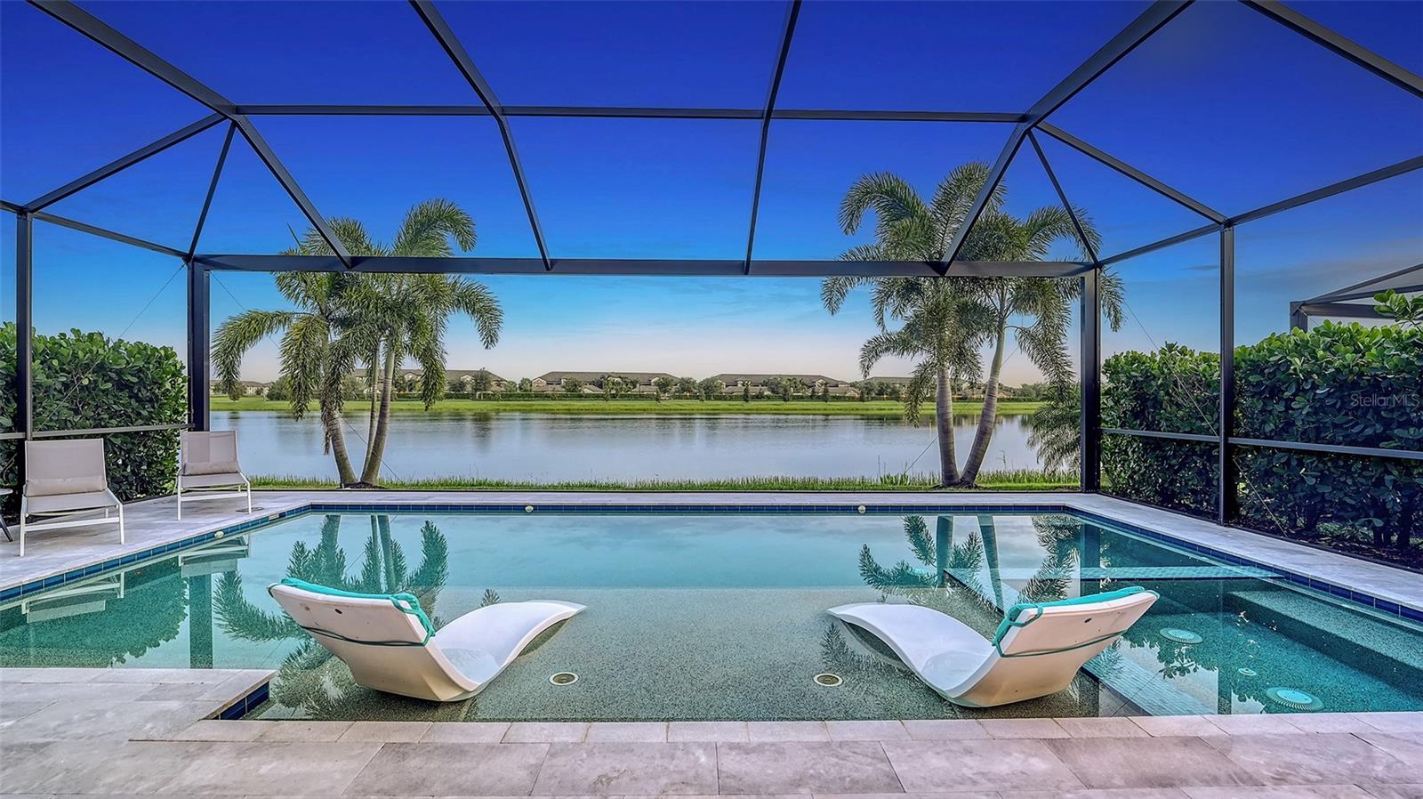 Experience the ultimate blend of luxury, comfort, and resort-style living at 17604 Hickok Belt Loop a Fully GOLF DEEDED home in the prestigious Lakewood National Golf Club. This Stunning Angelina open floor plan home offers everything today’s discerning buyers desire, from breathtaking lake views to an array of exceptional amenities.
Upon entry, the expansive water views draw you through the elegantly designed living space and out to the Travertine Tiled Lanai. This outdoor haven features a grand rectangular Pool with Sun Shelf & Spa, perfect for relaxation, while the panoramic screen and swaying palms provide a serene backdrop. The lanai is crafted for effortless indoor-outdoor living, complete with a wood-paneled ceiling and a fully equipped outdoor kitchen, making it ideal for entertaining or unwinding in style.
Inside, the home exudes casual elegance with a pale-toned gourmet kitchen that boasts a cooktop, wall ovens, extensive counter space, an island sink, and a convenient pass-through to the outdoor kitchen. Architectural details such as beamed ceilings and wainscoting enhance the warm, inviting atmosphere, blending sophistication with functionality. Full Block construction, Cement Tile roofing and Impact Glass windows throughout, ensures this home is ready for any Florida storms.
Situated on a generous 7,998 square foot lot, this residence is a gateway to a lifestyle akin to living in a luxury resort. As a resident, you have membership access to 36 holes of Arnold Palmer-designed golf courses, two on-site restaurants, and two bars. The community offers a wealth of amenities, including a state-of-the-art fitness center, spa/salon, lighted Har-Tru tennis courts, pickleball, bocce ball, and resort-style pools. The grand dining clubhouse and tiki bar provide perfect spots for socializing and dining.
This home is not just a place to live; it’s an invitation to embrace a lifestyle of unparalleled luxury and convenience in a vibrant full resort-style golf course community.