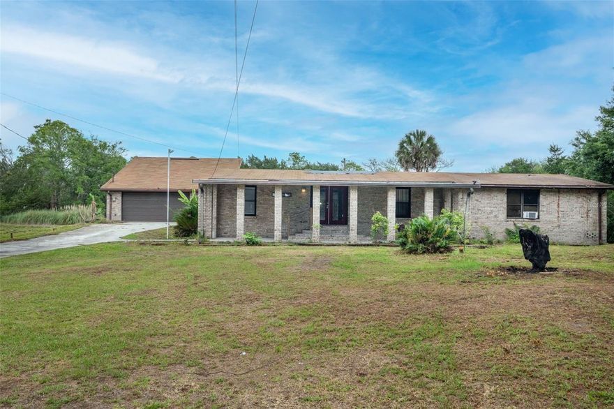 Canal-front home on Black Hammock Island situated on a quiet and secluded 1.13-acre lot featuring a sizable pond and scenic water views. Originally a manufactured home, the residence has been bricked in and expanded with a substantial addition featuring its own private entrance, and is now classified as a single-family home. This spacious property offers a large primary suite, a private in-law suite, and three additional guest bedrooms with a shared bathroom, making it ideal for multigenerational living. Enjoy outdoor living with a covered front porch and a side covered porch connecting the main house to the oversized detached garage of nearly 1,000 sq ft. The detached garage was originally designed as a 3.5-car tandem garage, with one bay converted into additional living space that can be used as a flex room and features its own window unit. The garage still offers ample storage space, currently utilized as a laundry room, along with attic storage and an upper-level patio and a large deck overlooking peaceful views. A large deck attached to the garage overlooks the canal and pond, providing the perfect setting for entertaining or relaxing in a peaceful, tranquil environment. The property is in need of repairs and updates and is being sold as-is. Contact the listing agent for additional details.