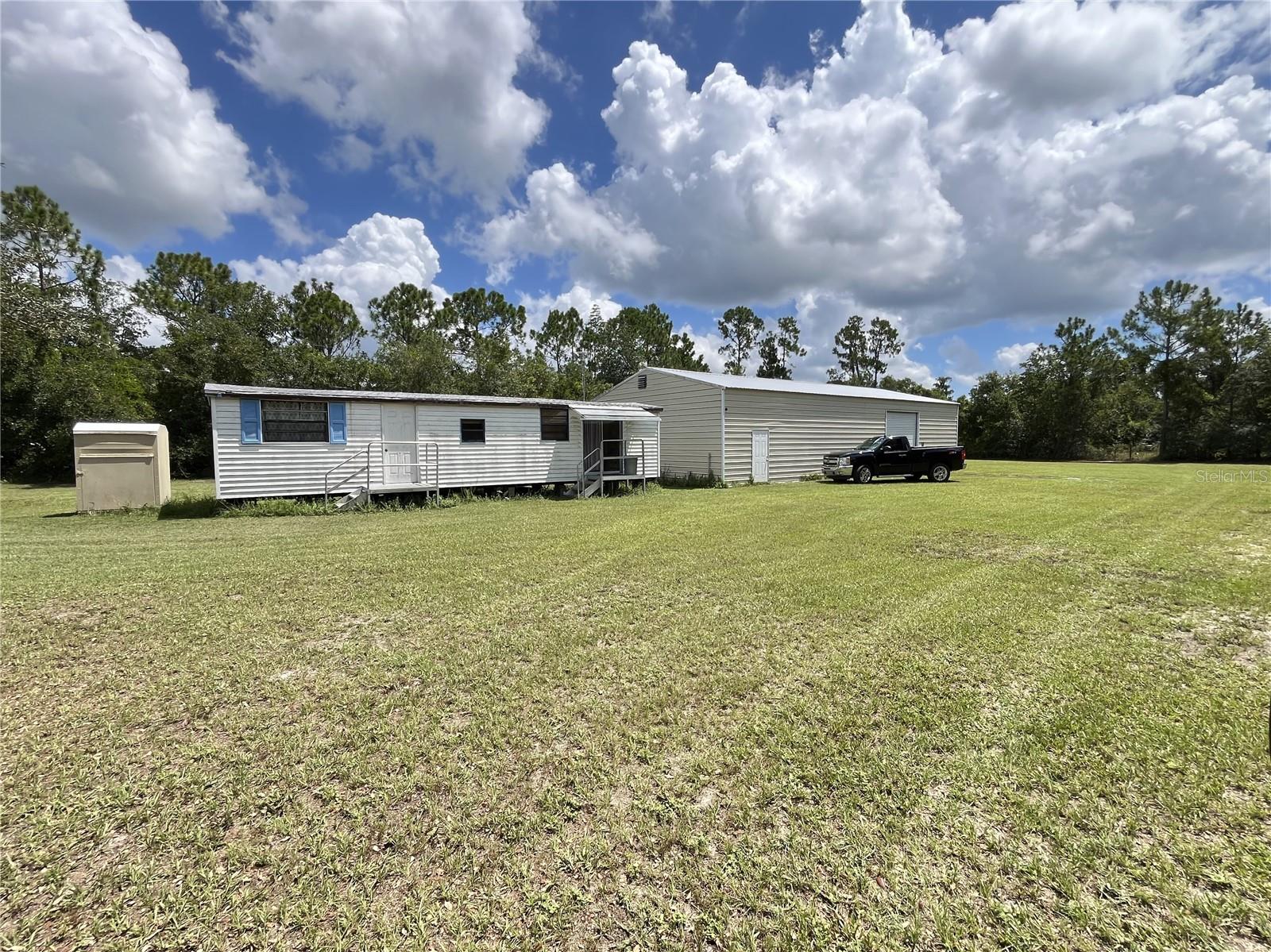 Looking for country living? Here it is! This 5 beautiful acres in Osteen is a short drive to Orlando or the beaches. On the property you will find 2 ( 1 bed 1 bath) park model mobile homes. In addition there are 2 large garages. A mechanist or hobbyists dream space! One is 30X 60 with a bathroom, an loft area, and 9,000 LBS car lift. The other is 25X 40, nice size to hold lawn mowers or tractors. There are a few other structures that can be used for feed storage or tack rooms. The property is fenced so bring the farm animals!