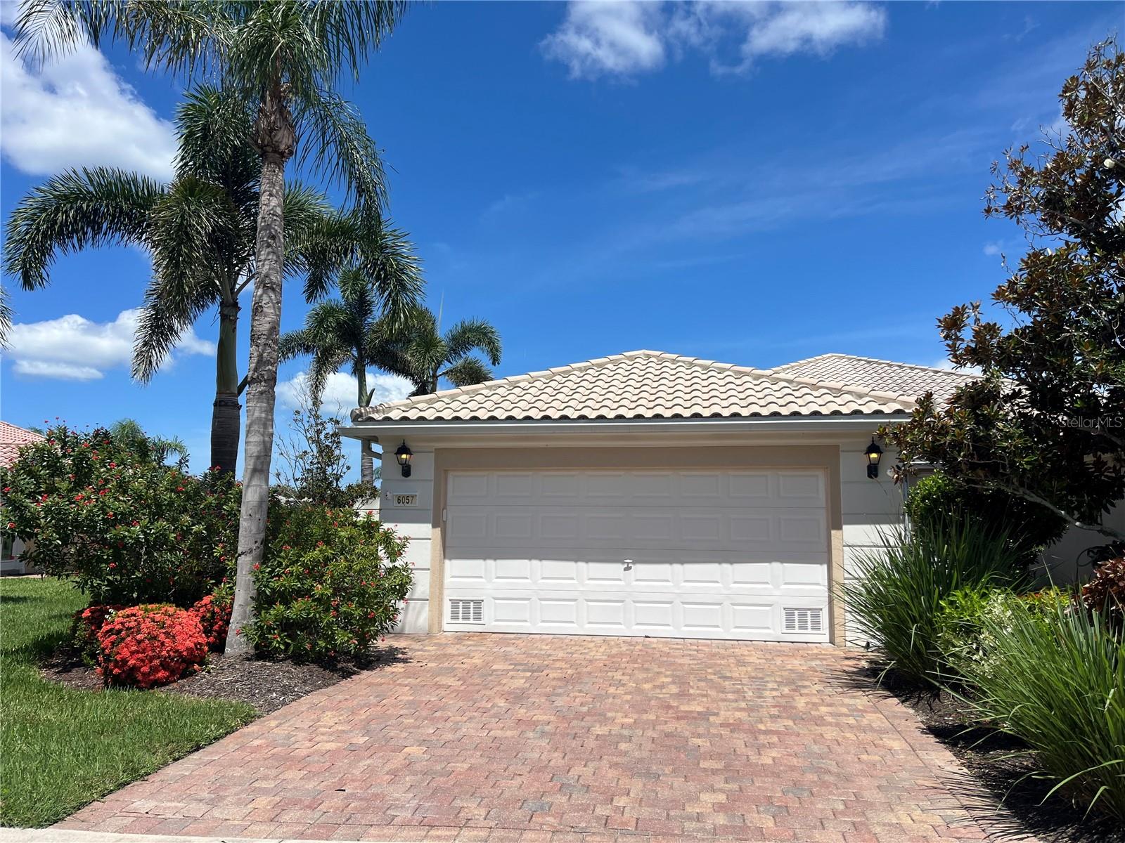 Resort-style living close to beaches, shopping, and restaurants! This maintenance-free villa, nestled within the gated and highly desirable community of Islandwalk, has been meticulously maintainted by the original owners. A beautifully landscaped private entrance welcomes you home. With its sunny southern exposure, the interior is bright and cheerful throughout the day. Enjoy quiet evenings at home or entertain guests with ease in the open, inviting layout. The kitchen features abundant storage and a convenient breakfast bar, while the dining room is ideal for formal gatherings. From the dining area and private lanai, take in tranquil views of the sparkling lake.Wake up to peaceful lake views in the spacious primary suite, which boasts a large window, a generous walk-in closet with built-in shelves, and ample space. The split bedroom arrangement ensures privacy for both you and your guests. For added peace of mind, Accordion Shutters are installed on every window and are easily activated. Lifestyle is the key word here! Islandwalk offers two clubhouses with resort-style and lap pools, spas, fitness centers, 12 lighted pickleball courts, 8 Har-Tru tennis courts, basketball, bocce ball, a dog park, and miles of scenic trails. Beyond the gates, you’re just minutes away from Manasota Beach, Venice Beach, and charming downtown Venice with its shops, restaurants, and theater. Nearby, enjoy the excitement of the Atlanta Braves' spring training at CoolToday Park and the vibrant Wellen Park community with shopping, dining, kayaking, and more.Whether you're looking for a full-time residence or a seasonal retreat, this is the perfect place to call home!