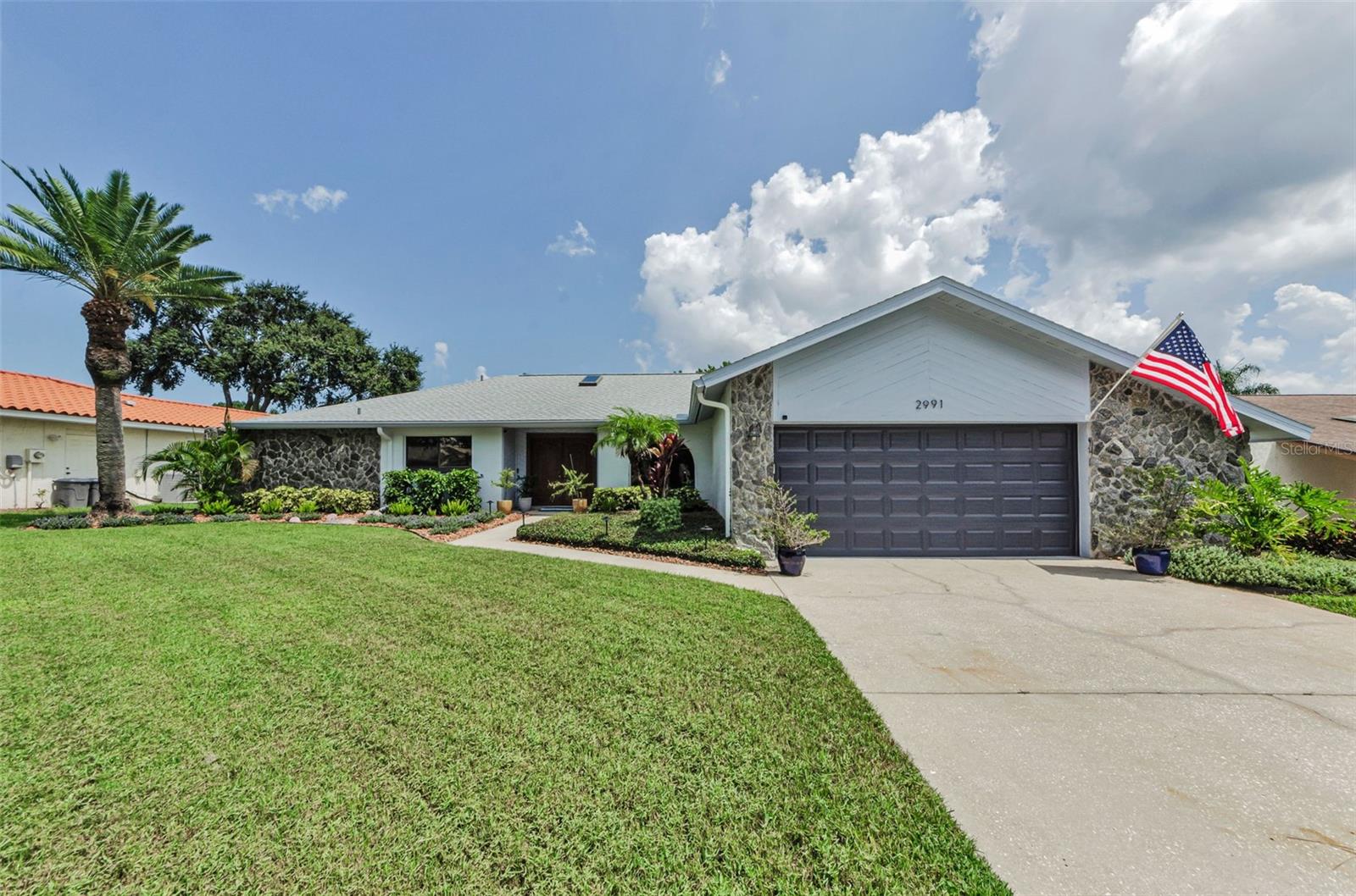 Welcome to an exceptional residence nestled in the esteemed Lake Valencia community of Palm Harbor! This 4 Bedroom, 2 Bath, Pool home seamlessly blends modern sophistication with the tranquility of Florida living. The heart of the home is its state-of-the-art Kitchen, featuring a Jenn -Air cooktop surrounded by a waterfall quartz island, designer cabinets are sleek with a pull-out pantry for all your storage needs, WAIT, there's more, you have your own wine chiller & ice maker & granite sink as well! Plenty of cook space, with an eat-at breakfast bar! Perfect for entertaining, this Kitchen is certainly the hub of the house as it overlooks the spacious Family Room with Fireplace and access to your backyard oasis! Upon entry, you are greeted by brand new hurricane impact solid wood doors. The Living area boasts a tropical centerpiece under a sunlit skylight, creating a warm and inviting ambiance. The split floor plan ensures privacy, with the Primary suite offering a spa-like ensuite bath, while three additional bedrooms cater to the family needs or a home office set-up. The inside Laundry room is even adorned with new sink, quartz counter and stackable washer/dryer! The outdoor space boasts a peaceful pool area, outdoor shower, screened lanai, plenty of space for your outdoor dining, and more! Seven brand new TV's are included with the home with all new cellular wiring, there is a new dog run for your furry pets, lush & update tropical landscaping, lighting and more! Home is outfitted with remote shades in Family Room, and Plantation Shutters throughout! Don't miss this one, gorgeous home, close to great schools, shopping, houses of worship, beaches, and all of the perks of Florida living! Lake Valencia is a deed-restricted community centered around a lush, serene lake with play area with seating to enjoy the tranquil views. A/C 2021, Roof 2018, Hot Water Heater 2019
