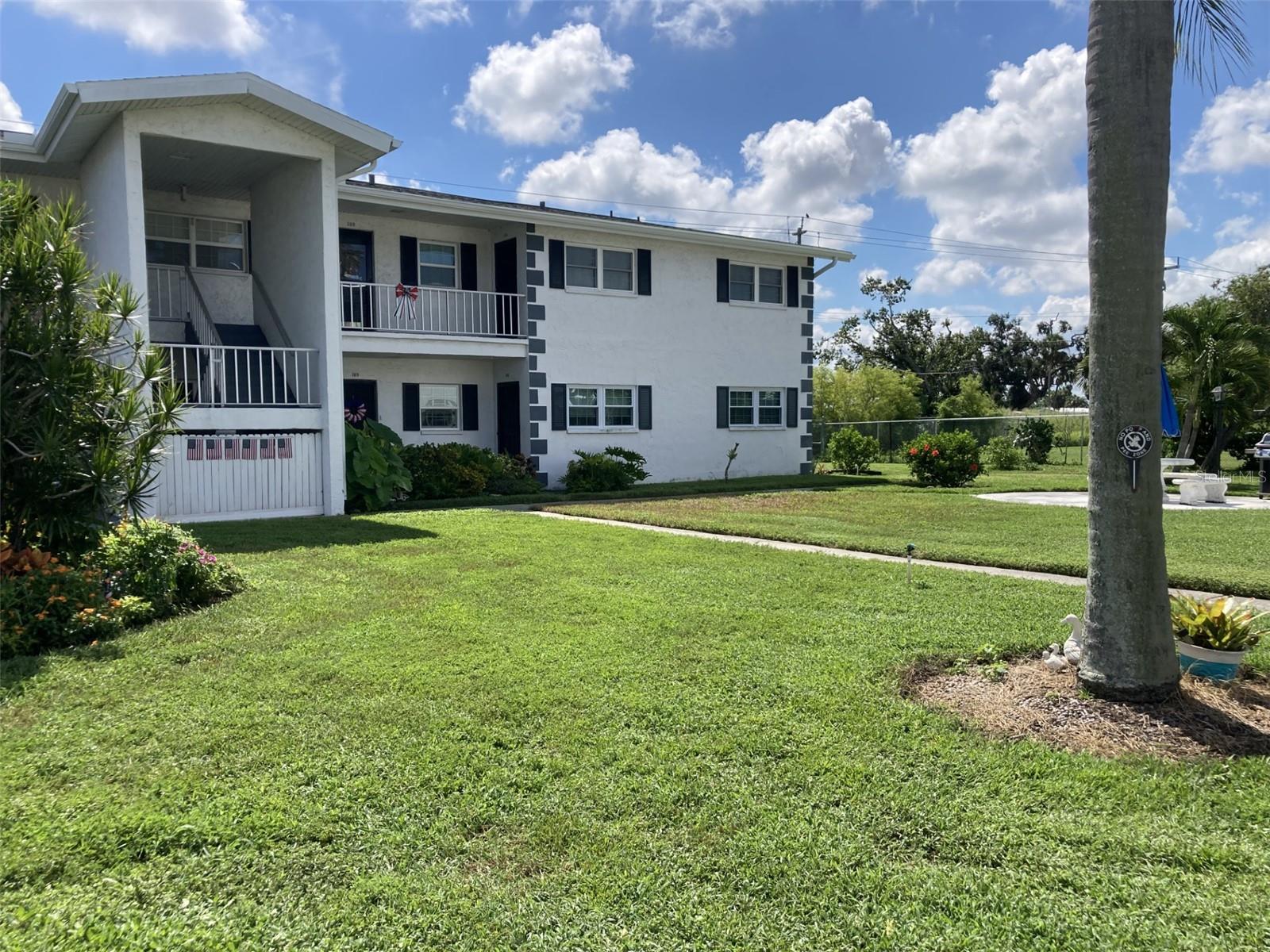 Exceptionally nice first floor corner two bedroom/one bath condo in the Burgundy 55+ complex. This condo is being sold turnkey furnished except for personal items and pictures that seller will remove. The condo is located at the back of the complex across from Greens of Manatee golf course. The kitchen has been updated with recessed ceiling and lighting, cabinets, solid surface countertops, appliances, including built-in microwave and stainless steel sink. The bathroom has a tub with newer surround tile, ceiling has been recessed, vanity, toilet, mirror and lighting updated. There is a full size stackable washer and dryer in the second bedroom. Other updates - laminate flooring, ceiling fans, interior doors, windows replaced in 2017. etc. The rear porch has been enclosed, has ceramic tile flooring and overlooks Greens of Manatee. Just outside the condo is a picnic table and grill - perfect place for a gathering. The community features a clubhouse, laundry facilities, heated pool and shuffleboard. Close to shopping, public transportation and about ten miles to the beach. In 2025 the roof and gutters were replaced, building has a new electrical meter, and new stacks.