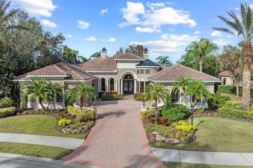 This spacious family home, and former model crafted by renowned builder Lee Wetherington, exudes casual elegance with custom architectural details throughout. Situated in the sought-after Legends Walk section of Lakewood Ranch Country Club, the home features exceptional craftsmanship from the exterior elevation to every interior room.  As you enter through custom hurricane-rated double doors, you're welcomed into a bright living space with a lighted coffered ceiling and crown molding. The living room offers oversized windows, a natural gas fireplace, and built-in cabinetry, creating a warm and inviting atmosphere. The dining room is enhanced by a custom-built buffet with quartz countertops, lighted glass display, wine refrigerator, and wine storage.  Throughout the home, you'll find unique ceiling treatments, woodwork, and inlaid wall tiles that set it apart from other properties. The chef’s kitchen is a highlight, offering quartz countertops, dual granite composite sinks, two dishwashers, a 6-burner gas stove with griddle and pot filler, a built-in refrigerator, an oversized convection oven with a separate microwave, and a warming drawer. The open floor plan, which seamlessly integrates the kitchen, café, and great room, is perfect for family gatherings and entertaining.  The great room opens up to the outdoor area with corner disappearing sliding doors that lead to a summer kitchen, a built-in grill with an exhaust hood, granite countertops, and a gas fireplace. The large lanai has plenty of room for dining and relaxing by the multi-level custom pool and heated spa, offering stunning lake view along with overlooking the newly renovated Cypress Golf Course and the 7th greens.  For entertainment, the game room is ideal for playing a friendly game of pool, featuring custom-built cabinetry, a window seat, a wet bar, and double sliding doors that open to the lanai. The home office, which can also serve as a 5th bedroom, is positioned privately and is equipped with custom built-in cabinets, shelving, and a desk, along with a ½ bathroom.  The primary suite is a true retreat, featuring a large bedroom overlooking the pool and lake, tray ceilings with crown molding and rope lighting, and two walk-in closets with built-in cabinetry. The luxurious en-suite bath includes two vanities with quartzite countertops, a walk-in shower, a soaking tub, and a private garden area with access to an outdoor shower.  The split plan design includes 3 additional bedrooms, a Jack-n-Jill bath, and another full bath, along with a laundry room with quartz countertops. More notable features of this home include a 4-car garage with hurricane-rated doors and epoxy floors, a newer roof (installed in 2016/2017), 2 Carrier HVAC systems (installed in 2017), and 2 new water heaters (installed in 2022).  Located in an upscale gated community with opportunity for golf and tennis membership to play on 4 premier Championship courses operated by award winning Heritage Golf Group.  This home is just minutes from UTC Mall, dining, beaches, and medical facilities in the Lakewood Ranch/Bradenton/Sarasota area.  A must see to truly appreciate!