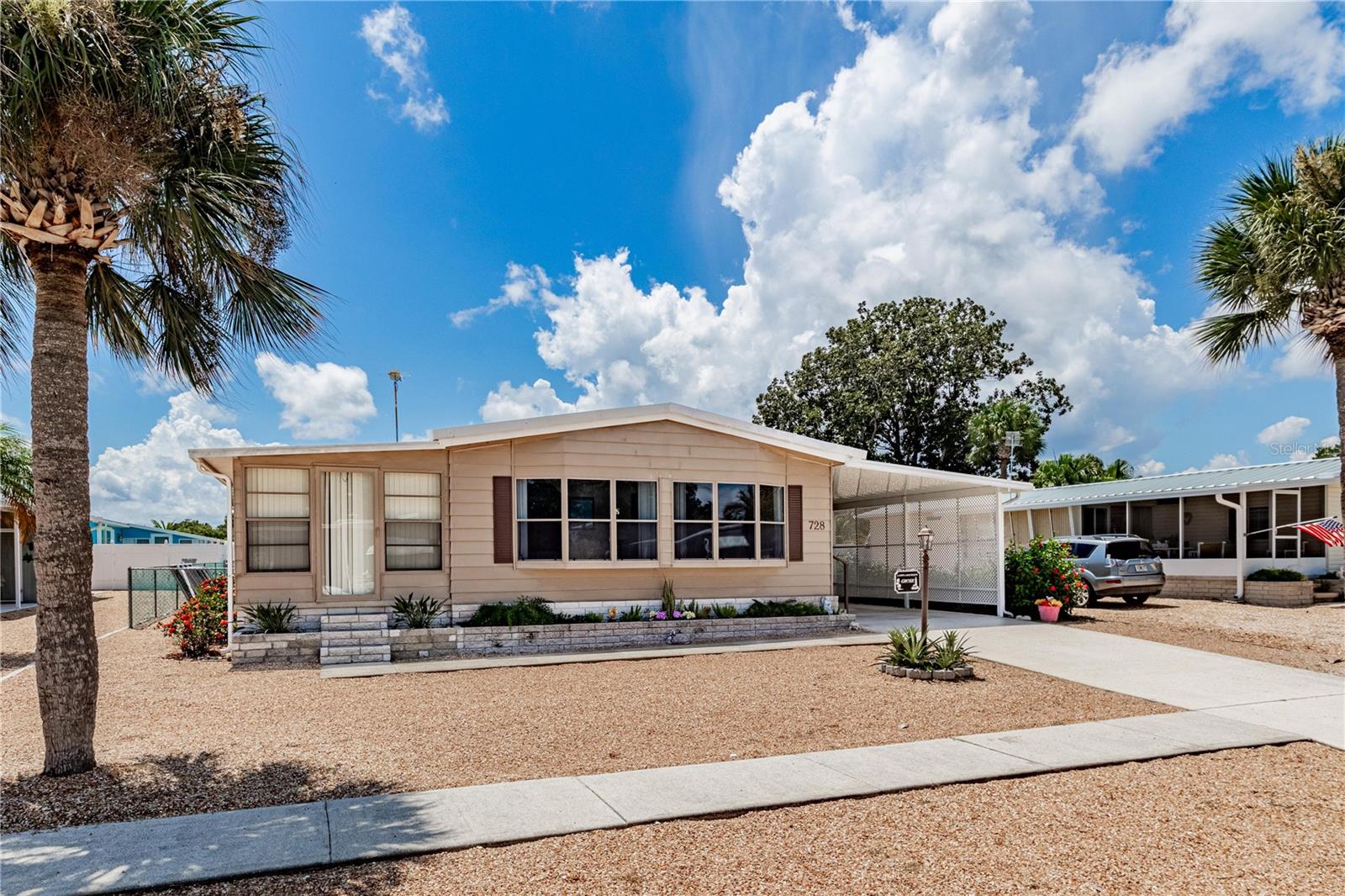 The property features an oversized 3-car carport with storage shed, a newer A/C and water heater, and beautiful 20-inch porcelain tile throughout. Inside, you’ll find a convenient laundry room, a large master suite with a walk-in closet, and upgraded details including new sinks, a stainless steel kitchen sink, and Price Pfister faucets.
Step outside to your private inground pool, complete with brand-new pump equipment and a backup pump for peace of mind.
Best of all—you own the lot! No lot rent, low taxes, and an HOA fee of only $25 annually. This maintenance-free home is centrally located, making shopping and everyday conveniences just minutes away.
Don’t miss your chance to enjoy the perfect blend of comfort, style, and convenience in one of the area’s most desirable communities.