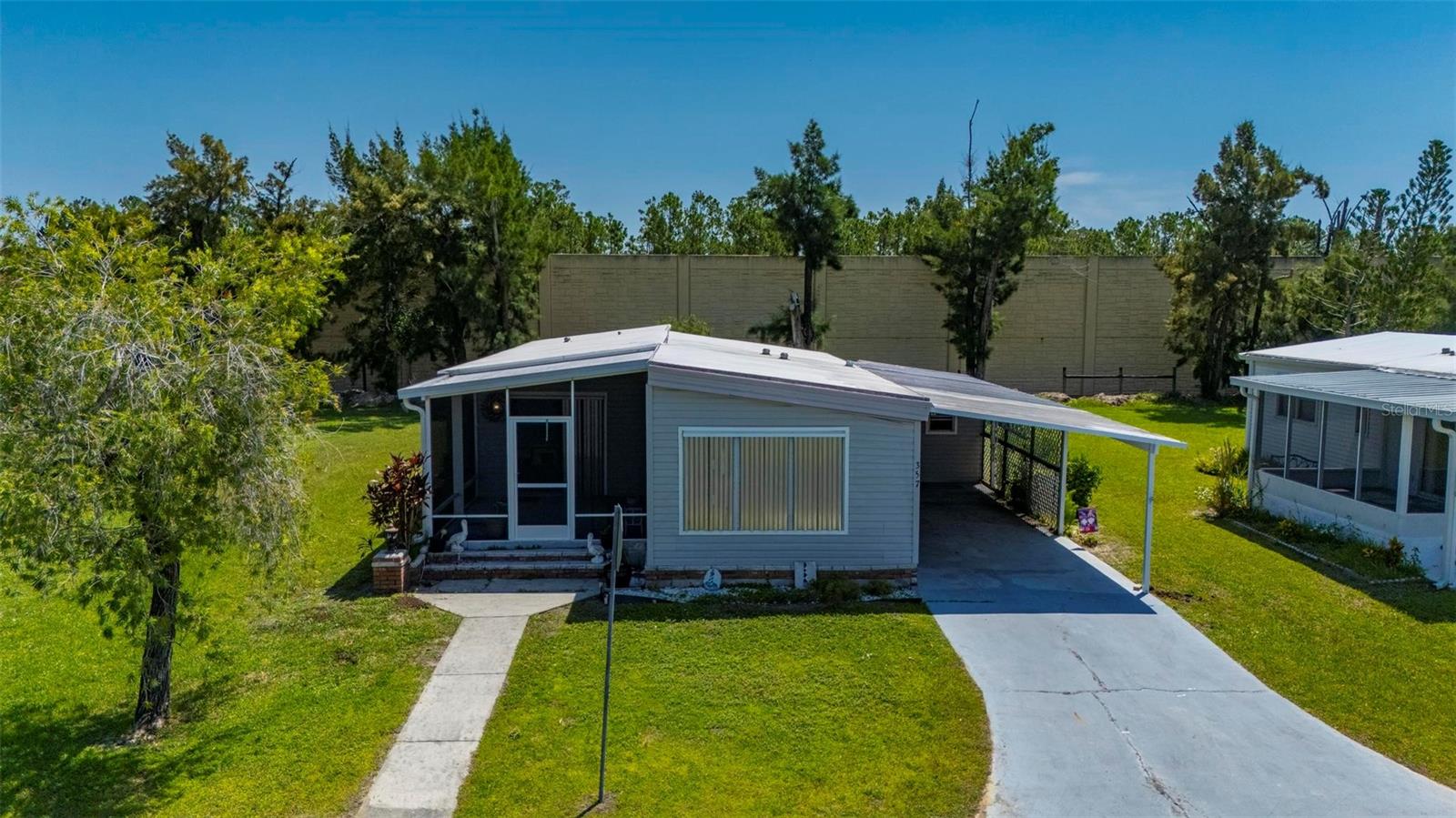 * Port Charlotte Village was Voted #1 in Charlotte County in 2024* Not in a Flood Zone
Welcome to this charming 2-bedroom, 2-bathroom manufactured home located in a desirable 55+ co-op community. This well-maintained residence features a split floor plan offering comfort and privacy, along with a spacious open kitchen that flows into the dining area and a cozy living room. The living room opens to a screened-in front lanai—added in 2015—perfect for relaxing and enjoying the Florida breeze. Both bedrooms are generously sized and offer plenty of closet space. A sliding glass door from the dining room leads to a private rear patio, ideal for outdoor dining or morning coffee. The long covered carport fits two vehicles, and the attached shed includes a washer and dryer with additional space for a workshop or extra storage.
Recent upgrades include a full home repipe completed in 2023, a newer water heater from 2022, and an HVAC system replaced in 2015—offering peace of mind and added value. This vibrant community is conveniently located near elite golf courses, excellent restaurants, a variety of entertainment options, shopping centers, and some of Florida’s most beautiful blue beaches—providing the perfect balance of relaxation and activity.
