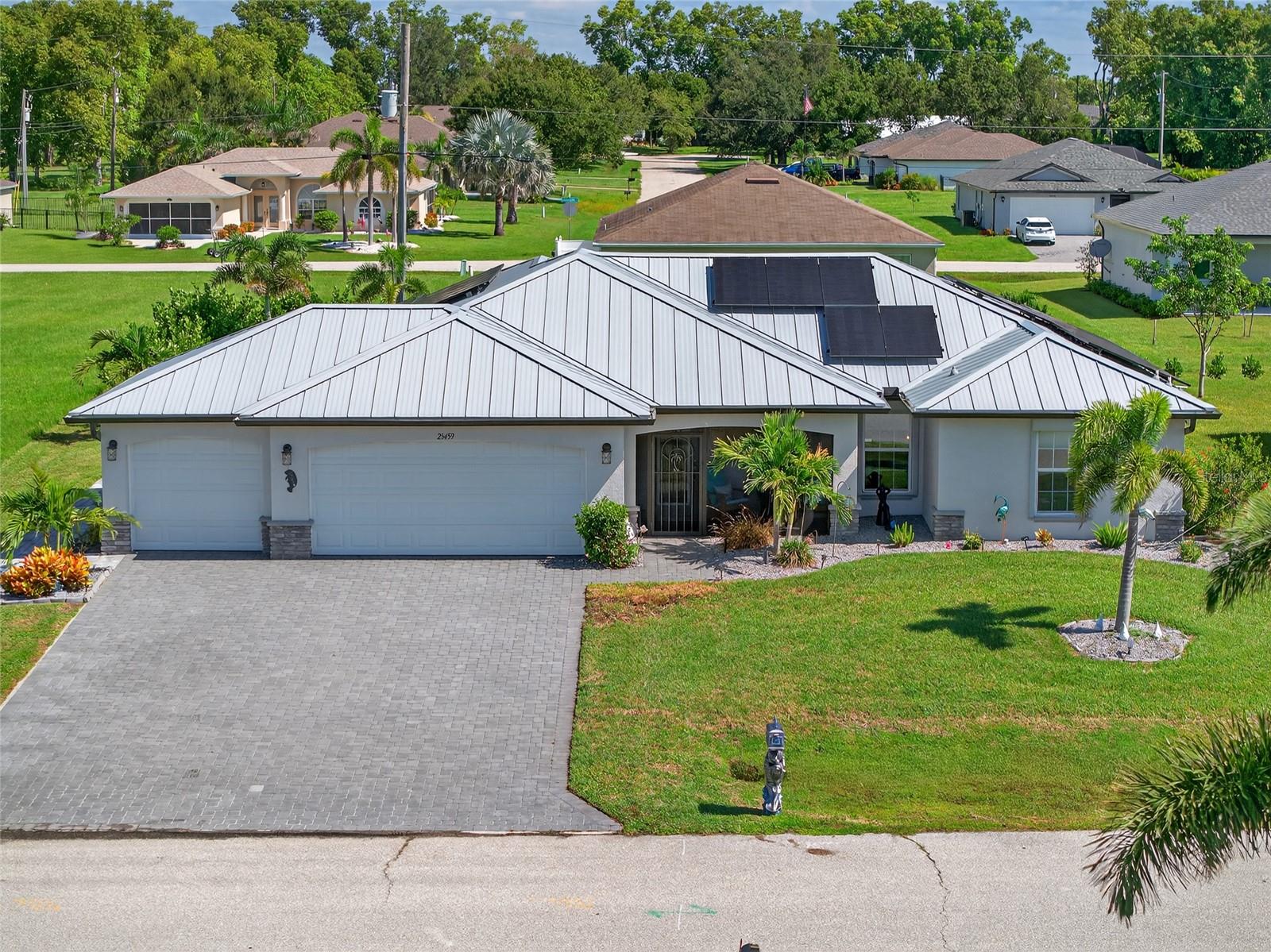 STUNNING 3 BEDROOM, 2 BATH, 3-CAR GARAGE POOL HOME IN BURNT STORE VILLAGE! BUILT IN 2021 BY CHRISTOPHER ALAN HOMES FEATURING THE GRAND PINELAND FLOOR PLAN! For ultimate peace-of-mind, this home includes roll-down window shutters, impact front door, roll-down Kevlar screen for lanai, whole house 22KW standby generator, standing seam metal roof and whole home solar system providing maximum energy efficiency and cost savings on your monthly electricity.
Cozy screened front porch leads into an open floor plan featuring high ceilings, contemporary décor and lighting, an abundance of natural light, custom window treatments, large slider to lanai and tile flooring throughout. Well-equipped kitchen offers granite counters, new stainless appliances, closet pantry and large center island with breakfast bar – ideal for casual dining. Generous primary suite features private ensuite with dual sinks, his and hers walk-in closets with custom organizers and large walk-in shower. Split floor plan provides plenty of privacy for guests with separate hall to two bedrooms and separate full bath. Amazing outdoor entertaining area features covered lanai, spacious paver pool deck and screened 12x24 heated saltwater pool with beach ledge. Additional features include epoxy flooring and plenty of storage in the 3-car garage, irrigation system, greenbelt for added privacy and nicely landscaped ground. The location of this property is unbeatable, just 20 minutes from downtown Punta Gorda and 30 minutes from downtown Fort Myers. Additionally, it's close to the relaxed waterfront community of Burnt Store Marina, offering access to resort and golfing facilities, waterfront dining, and entertainment. It is conveniently located to the airport, restaurants, shopping and award-winning fishing and boating. This home is truly move-in-ready and has it all! Schedule your private showing today!