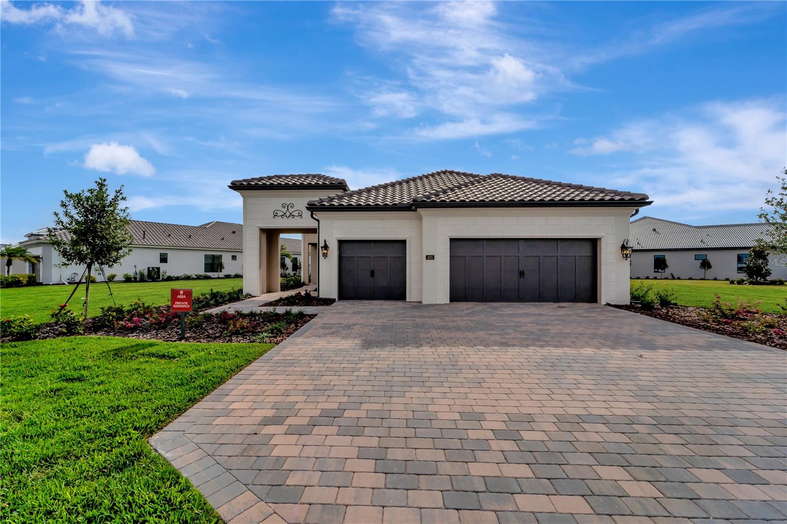 One or more photo(s) has been virtually staged. Modern Luxury meets timeless Elegance. With a beautiful Northern Italian Elevation, this home offers all the upgrades that you would expect. The Vincenzo model is a Neal Signature community home with volume 12 ft ceilings throughout and 8 ft doors giving the home a grand feeling. The home features, 3 Bedrooms, 2 Baths and a Den with 3-car garage. Placed on a large (.42 acre) oversized lot providing greenspace on both sides of the home with the most amazing water view that will re-charge you every day with natures beauty.
When you walk in the front door you are greeted with the reflection of water on your beautiful, upgraded, glossy tile in your Great room. The open floor plan is conducive to entertaining. Your gourmet kitchen is everything you want from beautiful, double stacked cabinets with glass and lighting, wall oven, custom hood and stainless-steel appliances. There is also a beverage room with sink, beverage refrigerator and wine cooler. The guest bedrooms have luxury vinyl flooring, there is No carpet in this home. The Master bedroom is spacious with custom closet shelving and ensuite bathroom with upgraded fixtures and free-standing tub. For those who love to live outside, open the Pocket sliding doors to your large lanai with lap pool and outdoor kitchen on upgraded crushed shell pavers. For your peace of mind, there is IMPACT Glass throughout. List of upgrades is attached. This is a BRAND-NEW home and has not been lived in. The community offers wonderful amenities including Clubhouse, Fitness Center, Community Pool, Spa, Pickle Ball, and Lifestyle coordinator. Let this home be the canvas for your Lifestyle. The location is perfect. An easy drive to beaches, shopping, restaurants and to Sarasota's downtown nightlife, the arts, and farmers markets. This is a Lifestyle home, make it yours!