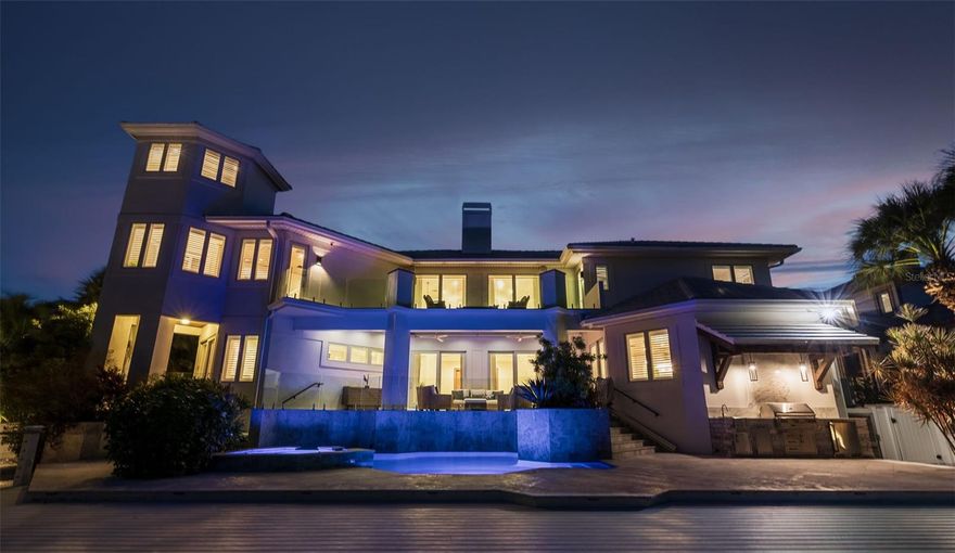 With 100 feet of deep-water frontage, boating enthusiasts will appreciate the private dock equipped with two boat lifts, two jet ski lifts, a kayak launch, and a private beach—all just minutes from the open Gulf of Mexico. Elegance, innovation, and coastal luxury converge in this remarkable Bayway Isles residence—masterfully renovated between 2021 and 2023 and reimagined for today’s modern lifestyle. Spanning over 5,500 square feet, this estate features six bedrooms, five full baths, and two half baths, blending refined design with state-of-the-art smart home technology. Upon entry, a sense of grandeur unfolds—soaring ceilings, rich hardwood floors, and custom architectural details set an elegant tone throughout. The main-level primary suite serves as a serene retreat, while two upper wings provide exceptional flexibility—one designed for extended family or in-law living, the other ideal for guests or a recreation area, complete with a fully furnished game room. Thoughtful touches such as wet bars, stone countertops, and three fireplaces accentuate the home’s craftsmanship, all seamlessly integrated through a Control4 automation system for effortless living. Outdoor living takes center stage with expansive decks, lush tropical landscaping, and a resort-style pool featuring dual propulsion swim systems. With 100 feet of deep-water frontage, boating enthusiasts will appreciate the private dock equipped with two boat lifts, two jet ski lifts, a kayak launch, and a private beach—all just minutes from the open Gulf of Mexico. Additional highlights include three dedicated offices, dual two-car garages with EV readiness, and the peace of mind of 24-hour gated security within the highly sought-after Bayway Isles community. Ideally situated just minutes from downtown St. Petersburg, the Gulf beaches, and Fort De Soto, with easy access to Tampa, Bradenton, and Sarasota, this home exemplifies elevated waterfront living. Notably, this residence did not experience flooding during the 2024 hurricane season—a testament to its solid design and enduring craftsmanship. More than a home, this is a statement of modern coastal style—a place where thoughtful design, luxury amenities, and timeless architecture unite in perfect harmony.