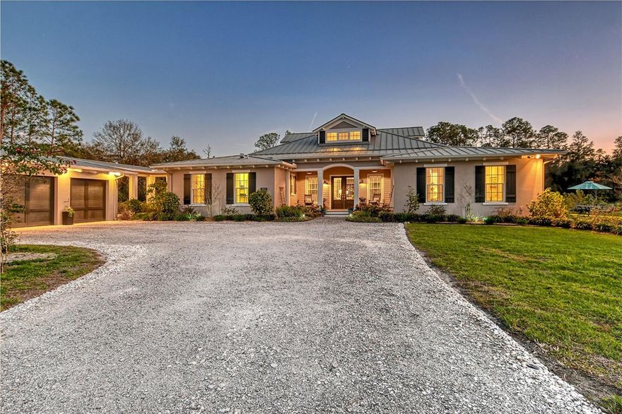 Welcome to an unparalleled masterpiece of modern comfort and natural beauty, crafted by Lee Wetherington Homes, named America’s Best Builder by the National Association of Home Builders. Nestled on 7.83 intensely private, wooded acres in the exclusive equestrian community of The Forest at Panther Ridge, this 4,236 sq ft estate, inspired by timeless Southern architecture, offers 4 bedrooms, 4.5 bathrooms, an exercise room, a game room, and a pool house, all designed for a lifestyle where the indoors and outdoors blend seamlessly. Built in 2014, this home features hurricane-rated windows and sliders that ensure both beauty and safety. Situated on a ridge and located in Flood Zone X, the highest and safest designation in the area, this property offers unparalleled peace of mind in any weather. Step inside to a breathtaking entry with dramatic 23’ ceilings adorned with striking beams, while the rest of the home features soaring 10’ ceilings throughout. The open common area seamlessly blends the gourmet kitchen, music room, dining room, and gathering space. Custom cabinetry with shaker-style doors, dovetail drawers, and soft-close features enhance the kitchen, complemented by elegant quartz countertops and stainless-steel GE Café appliances for a sleek, modern look. Oversized porcelain tile floors flow throughout, while 8’ solid core interior doors provide exceptional soundproofing and durability for added privacy and peace. The luxurious primary suite, with its en-suite bathroom, overlooks the pool and opens to the exercise room and east lanai.  Two additional bedrooms also feature en-suite bathrooms. The game room includes its own bathroom, and the laundry room even has a 48” dog bathing station! The pool features a Salt Chlorine Generator (a Florida GreenBuild feature) and a sun deck. Enjoy the gracious front porch on the north side, perfect for welcoming guests. The east lanai features a MALM wood-burning fireplace, adding a touch of mid-century modern elegance, while the west lanai overlooks the lake, offering sensational sunsets. Also overlooking the lake- a Ramada as well as a fire pit and deck, perfect for evening relaxation. The entire property is enclosed by 3-board fencing with no-climb dog fencing, ensuring privacy and security. This home is built to withstand the elements, with a standing seam metal roof featuring a durable Kynar finish and PGT Winguard impact-insulated low-e windows and doors, including Therma Tru impact French doors, providing unmatched protection and energy efficiency with Solar Ban 70 coating. The 3-course stem wall foundation, vapor barrier under the concrete slab, and steel reinforcement throughout ensure structural integrity. The engineered roof truss system is treated with borate, while R-19 Icynene foam and R-7 tailored foam inside block walls deliver superior insulation, soundproofing, and pest deterrence. Also included: Carrier 16 SEER HVAC system, a 50-gallon GE GeoSpring hybrid water heater, a 200-amp electric service with a subpanel for a future generator, and a 31x35’ 3-car garage with an electric vehicle charger. Located on a cul-de-sac, this estate is invisible from the road. The automatic gated entrance welcomes you to the property featuring stately oak trees, fruit trees, and a dedicated drive to RV parking with hookup and electric. The land offers ample space for stables or a workshop, offering flexibility for future expansion.  Act now—luxury and privacy await you.