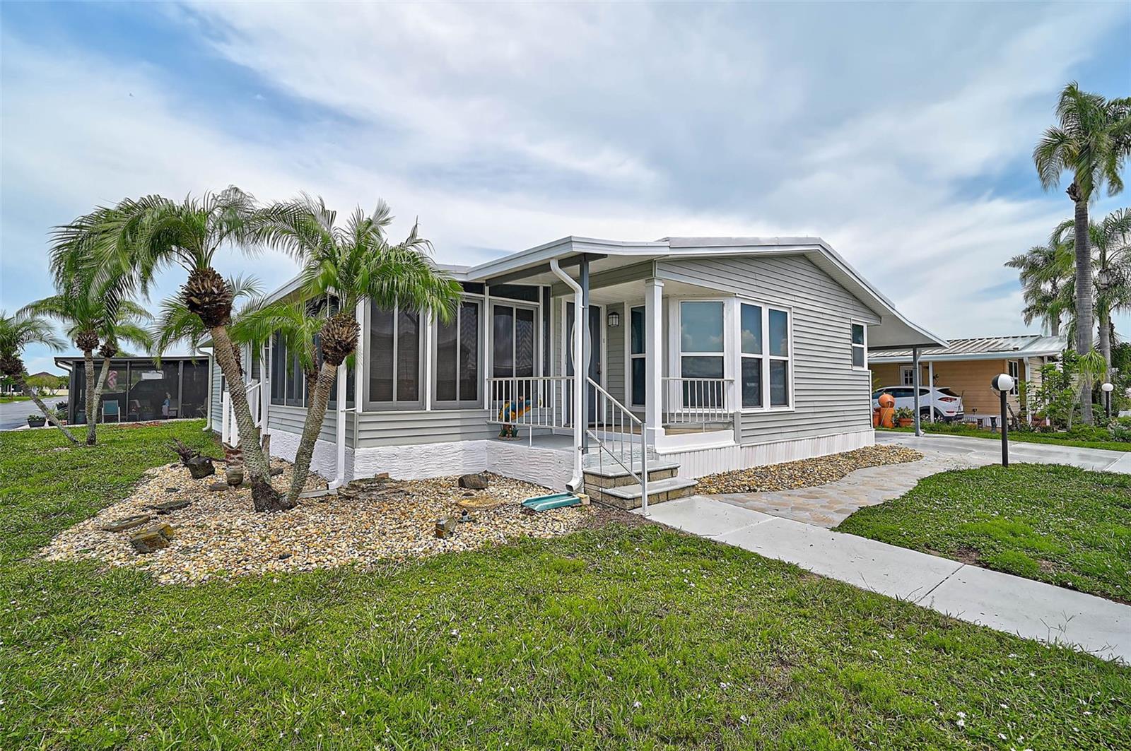 Welcome to this Turnkey-Furnished, double-wide manufactured home located in the sought-after 55+ community of Gold Tree CO-OP. This well-maintained home features 3 bedrooms and 2 bathrooms, with three convenient entrances and numerous updates throughout. The spacious primary suite includes a large closet and an en-suite bath with a skylight, New toilet, and New double sinks. The kitchen features a New sink, generous cabinet storage, and plenty of workspace for cooking and meal prep. Several rooms have been freshly painted, adding to the home's inviting atmosphere. System updates include a new A/C in 2018 and a roof replacement 2016. The enclosed lanai features tile flooring, a wall-mounted A/C unit, New screens, and New comfortable chairs- a perfect space to relax or enjoy a morning coffee. Just outside, the small open porch extends your living area into the outdoors. An oversized storage shed provides ample room for tools, hobbies, or seasonal items and is further enhanced with a convenient sink and an extra refrigerator—offering added utility for projects, gardening, or entertaining needs. The carport comfortably accommodates two vehicles. Additional highlights include gorgeous vinyl flooring throughout the home, making it both stylish and easy to maintain. Gold Tree CO-OP offers a friendly, active 55+ lifestyle with a wide array of amenities, including tennis and pickleball courts, shuffleboard, bocce ball, and an on-site fitness center. Relax and unwind in the community’s heated pool and hot tub or take part in social events at the clubhouse and library. Enjoy peace of mind with dedicated maintenance staff and an on-site management office that help keep the community in top-notch condition. With low HOA fees covering water, sewer, lawn care, internet, cable, and trash removal, this home offers outstanding value and convenience. Located near shopping, dining, medical facilities, and just a short drive to the beautiful Gulf Coast beaches, this home is ideal! Schedule your private showing today.