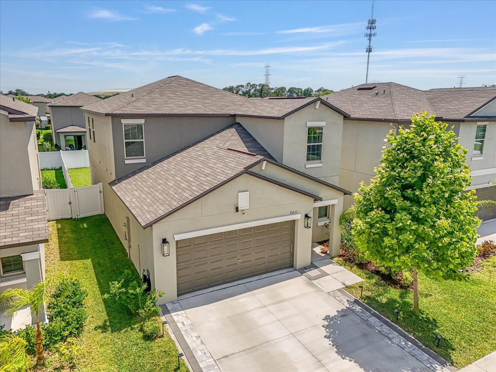 Newer, Upgraded Home Close to Downtown Tampa! ***This home is also available for purchase and qualifies for a $15,000 grant with NO income restrictions!*** Welcome to 7211 Ronnie Gardens Ct., Tampa, FL 33619—a beautifully upgraded 5-bedroom, 2.5-bathroom home for sale near downtown Tampa. Built in 2022 and offering 2,415 square feet of stylish and functional living space, this better-than-new construction home is packed with modern upgrades designed to meet all your lifestyle needs. Located in one of Tampa’s sought-after communities, this spacious two-story home combines convenience, luxury, and location. From the moment you arrive, you’ll be impressed by the home’s exceptional curb appeal, thanks to an extended paver driveway leading up to the attached two car garage, well-maintained mature landscaping, and tasteful exterior lighting that enhances the home’s charm both day and night. Inside, you’ll find brand-new luxury vinyl plank flooring throughout, elegant quartz countertops, designer hardware and fixtures, and stunning custom built-ins—including a welcoming entryway console with storage, a cozy fireplace wall, and a decorative feature wall that adds warmth and sophistication. The open-concept layout flows effortlessly through the living, dining, and kitchen spaces, creating an ideal setting for everyday living and entertaining. A large walk-in pantry offers ample storage, and the downstairs utility room comes complete with an included washer and dryer for added convenience. The downstairs primary suite is a private retreat with a luxurious en suite bathroom featuring a quartz double vanity, water closet, and a spacious walk-in closet. Upstairs, you’ll find a generous bonus loft—perfect for a media room, home gym, playroom, or office—along with four additional large bedrooms. Two of the secondary bedrooms include walk-in closets, offering flexible space for growing families or guests. The upstairs full bathroom features a thoughtful layout with a dual sink quartz vanity and a privacy door between the vanity and shower areas, making shared use simple and efficient. Step outside to a fully fenced backyard designed for relaxation and entertainment. Enjoy the beautifully paved patio, modern pergola with adjustable panels, roll-down shades, and string lights—creating your very own backyard retreat under the Florida sun. This Tampa home is located in a vibrant community that features resort-style amenities, including a zero-entry swimming pool with lap lanes, a fenced playground, and an upscale clubhouse with a fitness center and pool table. Whether you’re hosting guests or enjoying a peaceful day at home, this neighborhood offers the perfect mix of leisure and lifestyle. Conveniently located less than 15 minutes from downtown Tampa, with easy access to I-75, Selmon Expressway, local shopping centers, restaurants, and entertainment, this home truly has it all. If you’re searching for a move-in-ready, upgraded home avaialbe for lease, for sale, or a lease-purchase or lease to own, in Tampa with five bedrooms, a fenced yard, and luxurious community features—7211 Ronnie Gardens Ct. is your perfect match. #tampabay #tampa #downtowntampa #newer #centrallylocated #LVPfloors #quartzcountertops #fenced