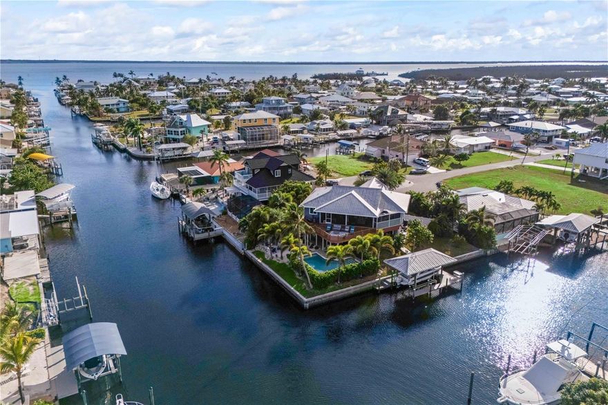 Tropical Waterfront Paradise with Endless Charm! Welcome to your own slice of paradise! Nestled on a peaceful cul-de-sac corner lot with 189 feet of stunning waterfront, this exceptional 4-bedroom, 3-bath home perfectly blends luxury, comfort, privacy, and Florida fun. Located on beautiful INTERSECTING CANALS, every day feels like a vacation. Step outside to your private resort-style oasis—take a dip in the heated pool, relax by the firepit, get comfortable with a book on the hammock, or wiggle your toes in your very own playful sandy beach area. Boating enthusiasts will love the covered dock with lift, ideal for easy Gulf access and sunset cruises. TWO MINUTES OUT TO OPEN WATER! Inside, discover a bright and inviting open floor plan designed for relaxing and entertaining. The gourmet kitchen is a chef’s dream, featuring stainless steel appliances, custom cabinetry, Corian countertops, a wine refrigerator and plenty of space for gatherings with family and friends. The main suite offers a peaceful retreat with scenic water views, while the versatile downstairs “in-law” suite which includes a full kitchen and laundry room, providing private accommodations for guests or extended family. Surrounded by lush tropical trees and vibrant landscaping, this home truly embodies the Florida lifestyle—a perfect balance of relaxation, recreation, and natural beauty. Whether you’re lounging by the pool, hosting sunset dinners, or setting out on a morning paddle, every moment here feels like a getaway. Come experience the joy of waterfront living—where every sunrise sparkles on the canal and every sunset invites you to stay just a little longer. Consider adding this home to your income producing portfolio by placing this Coastal Escape on the vacation rental market. This home is in high demand all year!