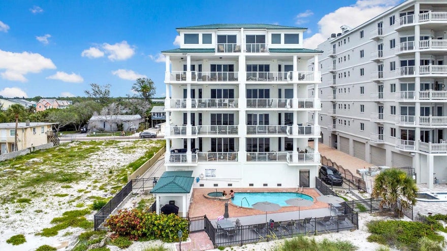 Introducing a rare opportunity to own a truly exceptional fully furnished residence at Fairwinds—an exclusive, boutique beachfront building comprised of only eight private residences, offering the ultimate in privacy, space, and refined coastal living. Encompassing an impressive 3,355 square feet, this luxurious condominium features four bedrooms, three-and-a-half baths,  perfectly suited for those seeking more than just a beach getaway. From the moment you arrive, you are welcomed by a secure lobby, private two-car garage, and a semi-private elevator that opens directly into your residence. A grand double-door entry leads into a light-filled foyer, setting the tone for the elegance found throughout. The expansive great room seamlessly blends sophistication and comfort, enhanced by natural light and thoughtfully curated, professional furnishings—this home is offered fully turnkey and move-in ready. The recently remodeled gourmet kitchen is a showpiece, featuring white shaker cabinetry, modern lighting, stainless steel appliances, a spacious walk-in pantry, and a stunning detached island adorned with soft blue cabinetry and brass hardware—perfect for both everyday living and entertaining. Step outside to your oversized beachfront balcony, where unobstructed Gulf views create a breathtaking backdrop for hosting guests or simply unwinding while taking in spectacular sunsets. The primary retreat is a sanctuary of luxury, complete with tray ceilings, recessed lighting, and a spa-inspired bath featuring a jacuzzi tub, dual-head glass-enclosed shower, and dual granite vanities. Each additional bedroom is beautifully designed, offering en-suite baths, private balconies, vibrant décor, and LED smart flat-screen TVs for ultimate comfort and convenience. Additional highlights include aerial-worthy views, strong rental potential with over $70,000 in income with returning guests if desired, and a level of exclusivity rarely found on the Gulf Coast.This is coastal luxury redefined—where privacy, elegance, and breathtaking views come together to create an extraordinary living experience.