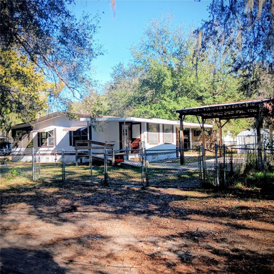 This 2/2 fully fenced doublewide home is a short distance to the expanding city of Ocala & moments to the popular Salt Springs National Park where you find the swimming holes for snorkle and adventure, kayaking, fishing & more!  Make this an AirBnB, full time residence or "snowbird" living.  Bring your RV,  Boat, Trailors and more as there is plenty of room on this property.  With a public boat ramp just (2) blocks away, enjoy fishing or a day trip on the lake.  Dues for boat ramp use is only $30/yr.   This corner lot 2/2 has a ramp and/or steps to access entrance. Fully fenced with chain link and wide gates to allow oversized vehicles.  Solid cement breezy screened Florida room provides a very spacious area. Cement pad carport.  The entrance room can become an office or breakfast area or indoor garden.  This 2/2 double wide sits a nice corner lot offering a nice space in the yard.  Come check it out!   This could be that one! CASH.  No Finance.