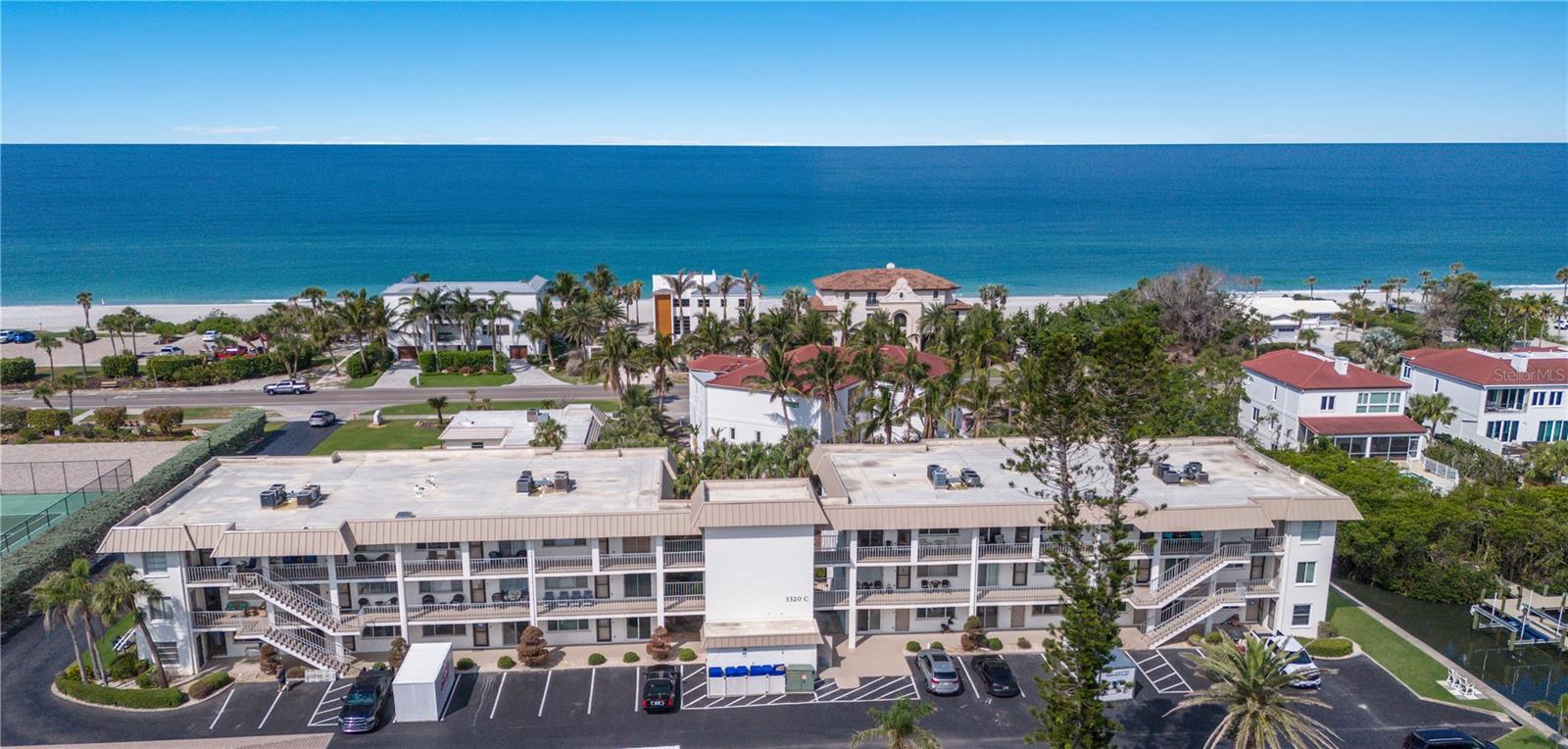 DEEDED BEACH ACCESS - Discover this 3rd floor (with elevator access) 2 bed, 2 bath condominium located in Longboat Arms a well-maintained community on Longboat Key, Florida. Move-in ready with bay views on the veranda. Enjoy entertaining in the unit with open floor plan that has 9' ceilings and a generous sized great room and dining area. The primary bedroom is also oversized with a walk-in closet and en-suite bath provides a peaceful retreat. This condominium has an in-unit washer and dryer, as well as added storage throughout. The AC was replaced in 2023, and flooring replaced in 2021. Residents will enjoy access to the private boat ramp, which is excellent for kayaks, paddle boards, jet skis, and various watercraft. Boat docks are available first come, first served for an annual fee, providing convenient access to the water for boating enthusiasts. Longboat Arms is a community that has great amenities, including an upgraded heated swimming pool, clubhouse, tennis court, community grill area and deeded beach access. The assigned oversized carports that can even accommodate boat storage and ample guest parking.
