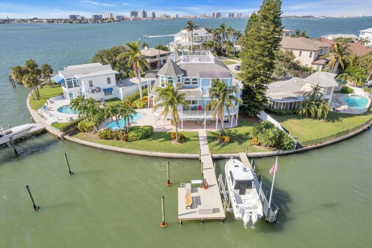 Nestled in Belleair’s most affluent communities. The residence promises panoramic water views from the best of paradise on a picturesque cul de sac. It offers an open concept four bedrooms, four bathrooms, 4,047 square feet of thoughtfully designed living space. Not to mention endless stretches of outdoor areas that take advantage of that view. Awash in natural light, the interiors were designed for entertainment. The first of three levels features your convenient three-car attached garage with work space and bedroom with a full en suite bathroom. French doors open to the main outdoor sundeck and pool with outdoor shower, where you’ll revel in the magnificent sunrises and sunsets daily. On your second level with direct access from the garage, is the open chef’s kitchen, breakfast nook, large dining room and open family room with wood burning fireplace that is perfect for gathering with friends and family. All seamlessly connecting to the huge balcony. The bedroom, full bathroom, and laundry room complete this level. On your third level is the spacious and inviting primary suite with a huge custom closet. Your dream master bathroom retreat features a freestanding bath tub, stand alone shower and vanity area. Another bedroom with ensuite bathroom, access to the widow’s walk and sitting area completes the third level space. Every room showcases breathtaking water views. But none like your secluded widow’s walk, giving you 360 degrees of daily sunrises, sunsets, and endless water views while enjoying nature's best with birds, dolphins, and fish in your own backyard. The home boasts new Simonton Hurricane windows, fully renovated master suite, bathroom and custom closet and flooring, fresh paint inside and out as well. New Seamount 20,000 lbs. boat lift and two new docks accommodating big and small boats with tie up system for even bigger boats on your 120 feet of protected waterfront. New roof was installed November 2023. This home is everything you’ve been looking for. Experience a world of ease and beauty bursting with spectacular views in a great town on a great block!