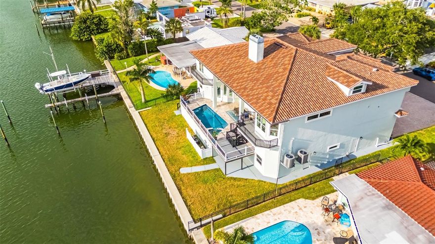 A reimagined waterfront estate in the coveted enclave of Island Estates, where modern coastal design meets elevated construction and uncompromising peace of mind—just moments from the sugar-white sands of Clearwater Beach. This fully renovated 5-bedroom, 4-bathroom residence has been thoughtfully curated for today’s luxury buyer, blending clean architectural lines with high-performance upgrades rarely found in waterfront homes. Built well above flood elevation, the home offers a unique advantage in today’s market—delivering both first-level living and an elevated pool experience, all on the main living level. Here, indoor and outdoor living seamlessly converge, allowing you to step directly from your living space to your private pool—without compromise.
Inside, an open-concept layout is anchored by a dramatic great room and a chef-caliber kitchen, featuring JennAir appliances, a gas range with pot filler, striking Zebra Cambria quartz surfaces, and custom soft-close cabinetry—designed for both entertaining and everyday sophistication.
The 1,200+ square foot primary suite is a true sanctuary, offering sweeping panoramic water views and a scale rarely seen in coastal properties—creating a private retreat that rivals five-star resort living.
Every detail has been elevated for comfort, efficiency, and long-term value, including: Brand-new Verea clay tile roof, Impact-rated windows and doors throughout, 3-zone American Standard HVAC system, Integrated central vacuum system, New seawall for long-term waterfront security, and RainBird irrigation system.
Outdoors, the property continues to impress with expansive entertaining areas, a sparkling elevated pool, and a newly installed seawall—offering the future owner the opportunity to design a custom dock tailored to their boating lifestyle. A rare highlight for Island Estates, the home also features garage space for up to 6 vehicles, including room for an RV or trailered boat—an invaluable asset for both full-time residents and seasonal owners. Positioned just minutes from Clearwater Beach, the Clearwater Marine Aquarium, fine dining, and vibrant local amenities, this residence offers the perfect blend of privacy and accessibility. For buyers relocating from New York, California, or other major metropolitan markets, this home represents a compelling alternative—delivering waterfront luxury, newer construction standards, and lifestyle-driven design at a fraction of comparable coastal properties. This is not just a home it’s a secure, elevated coastal investment designed for modern Florida living.