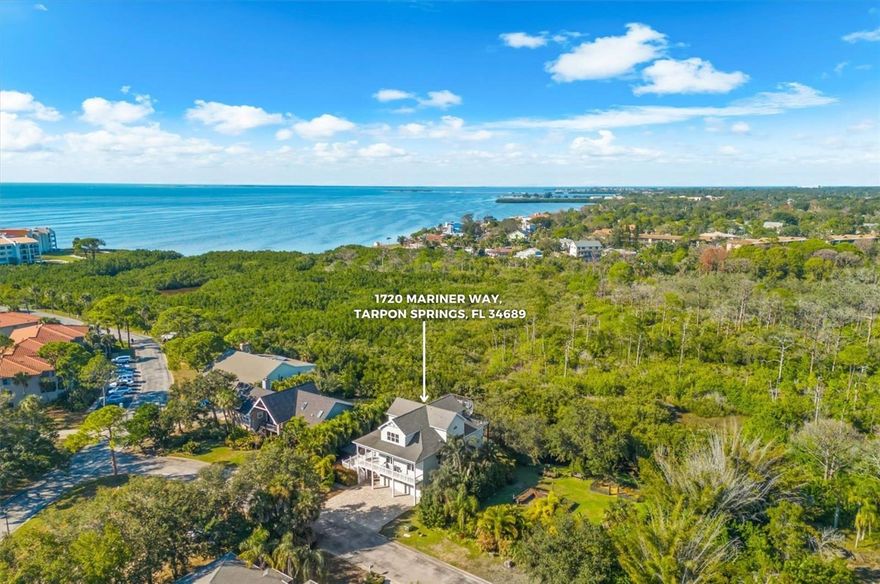 Discover this exceptional 4-bedroom, 3.5-bath luxury estate with screen enclosed private fiberglass pool, nestled within the gated waterfront community of Mariner Village. Built in 2016 to meet the newest hurricane standards, this elevated three-story home blends elegant design, modern functionality, and stunning western water views. A private boat slip at the community marina is available for lease, offering convenient deep-water access just minutes from the Gulf of Mexico.

Set on an oversized lot surrounded by lush tropical landscaping, this residence makes a striking impression with its extensive paver driveway, manicured grounds, and sophisticated architectural design.

Inside, a soaring foyer welcomes you into a bright and open living space featuring a gas fireplace, custom built-ins, and sliding glass doors that frame tranquil waterfront views. The gourmet kitchen showcases leathered granite countertops, a large island, soft-close cabinetry, walk-in pantry, beverage refrigerator, and premium stainless-steel appliances. The layout flows seamlessly into the dining area and covered patio perfect for entertaining or relaxed evenings at home.

The main level includes a flexible private office (optional 4th bedroom), an ensuite guest room, and a convenient laundry room. Upstairs, the primary suite offers a luxurious retreat with a custom walk-in closet, freestanding soaking tub, walk-in shower, dual vanities, and a private balcony - viewpoints of the Gulf of Mexico. From here, a spiral staircase leads to a rooftop viewing platform offering panoramic Gulf views and breathtaking sunsets.

The lower level features approximately 740 square feet of additional finished space (not included in main living area), currently used as a recreation area with ping pong table, home theater, and gym. Step outdoors to enjoy a resort-style screened lanai with saltwater pool, standalone hot tub, and plenty of space for lounging or play on an extensive paver patio.

Additional highlights include a two-car garage with tall ceilings and extra storage, multiple walk-in attics with spray foam insulation, hurricane-rated features, and elevator-ready construction. Residents enjoy a guarded gate, deed restrictions, and access to boating, kayaking, and fishing just steps from home.

Located minutes from Sunset Beach, Fred Howard Park, the Pinellas Trail, and historic downtown Tarpon Springs, this exceptional home offers an elevated coastal lifestyle, combining luxury, flexibility, and waterfront living at its finest.