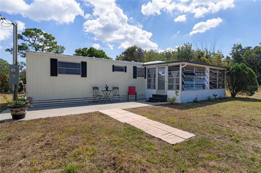 SOUTH PUNTA GORDA HEIGHTS GEM WITH SHADED BACKYARD - Enjoy laid-back waterfront living in South Punta Gorda Heights, a non-deed restricted community where flexibility and affordability meet Florida charm. This 2 bed/2 bath mobile home sits along a peaceful freshwater canal, offering tranquil water views and a relaxed outdoor lifestyle. SO MUCH POTENTIAL to build your Florida dream here. You own the land w/NO HOA or deed restrictions. Set beneath mature shade trees, the backyard invites you to slow down and unwind. A hammock overlooks the canal, creating a simple yet inviting outdoor retreat. The property offers flexibility - two detached sheds (both with electricity) add valuable storage and workspace options for hobbies, tools, or weekend projects. Plenty of room in the large yard for toys or equipment. Inside, the layout is efficient and filled with natural light. The main living area flows into the dining space and kitchen, creating an easy, everyday gathering area. Wood-look laminate flooring runs through the primary living spaces and bedrooms, while the bathrooms feature durable tile and vinyl finishes for low-maintenance upkeep. Two screened porches extend the living space outdoors—one welcoming you at the front entry and a second overlooking the canal at the rear. Whether relaxing with a book, entertaining friends, or simply enjoying the peaceful water view, these spaces enhance the Florida lifestyle. This well-maintained home offers tremendous potential for personalization, seasonal use, rental income, or full-time living. Located just minutes from US-41 or I-75, the home gives you easy access to historic downtown Punta Gorda, Cape Coral and Fort Myers. Make the most of all the area has to offer including waterfront parks, boat ramps, nearby golf courses, tennis and pickleball as well as miles of walking and biking trails. You are close to everything, yet the property manages to maintain a quiet, tucked-away feel. This is the perfect home to create the Florida lifestyle that fits you.