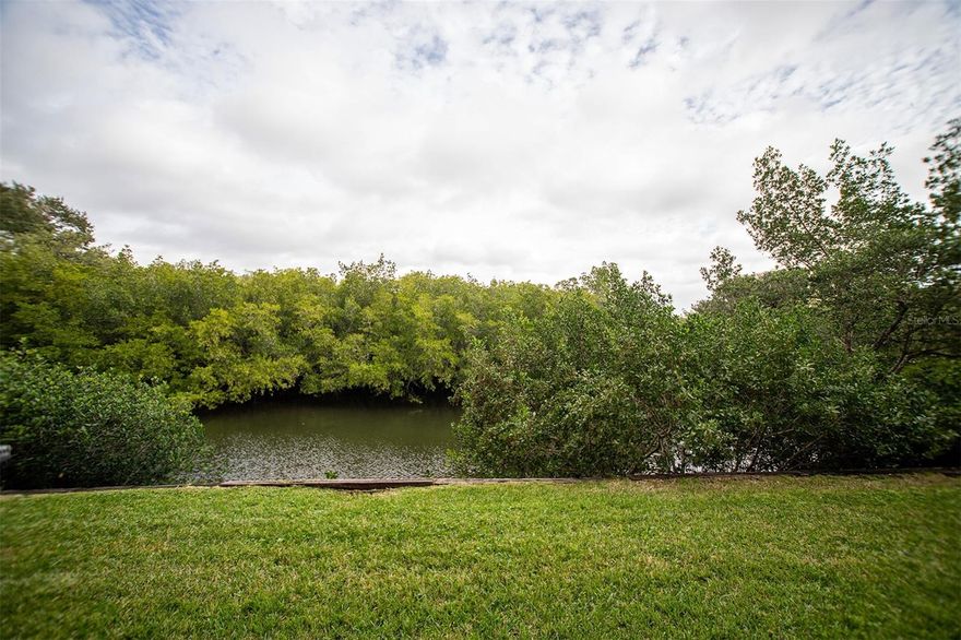 This ground-floor, inlet-front condo in the newest building at Cove Cay offers a comfortable, easygoing waterfront lifestyle with a front-row seat to nature.  Starting with an assigned parking space across from the front door for easy access and minimal stress when bringing in the groceries, you will enter to the functional kitchen, with a pass-through to the living area.  And it comes complete with stackable laundry for everyday convenience..  The two-bedroom, two-bath home features nicely updated bathrooms and newer light-toned waterproof laminate flooring throughout.  The very light and bright interior adds to the happy feeling of this delightful condo.  Sliding doors from both the living room and primary bedroom open to a screened porch overlooking the inlet, where manatees, fish, and a wide variety of birds are frequent visitors—an ever-changing natural backdrop you’ll never tire of.  Assigned parking is just steps from the front door. The Village clubhouse with  pool, spa, and recreation area is close by and now includes a newly added fitness room.  And the golf course is walking distance, if you like, or a super short drive. With golf, dining, marina access, lush landscaping, and 24-hour security within the community, this condo offers the relaxed yet well-appointed lifestyle in the paradise known as Cove Cay.