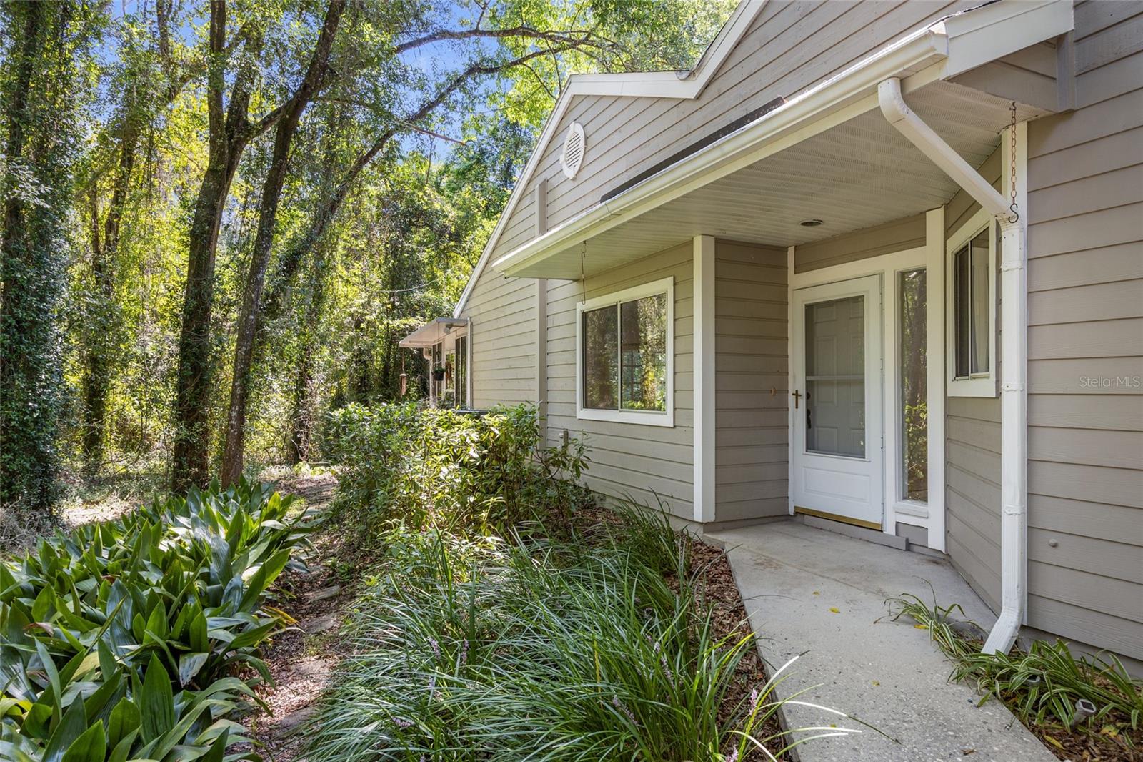 Welcome home to the Villas of West End, conveniently located exactly one mile from the Town of Tioga and approximately 7 miles to the University of Florida. This fantastic end unit is available for the first time in 27 years and features vaulted ceilings, an updated kitchen with granite counters, and a wood burning fireplace. There are three sets of French doors that lead out to a large Florida room with incredible views of the big beautiful trees in the backyard. The large covered porch definitely sets this unit apart from the others. Other notable features include fresh paint throughout and new carpet in the living room and the primary bedroom. Enjoy low maintenance living in a quiet location.