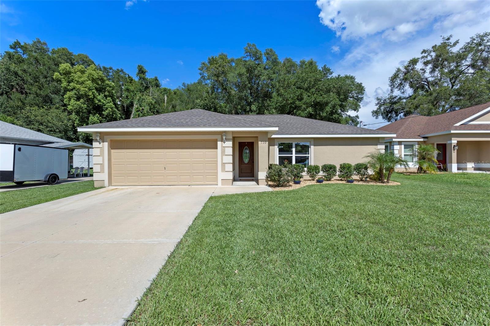 Discover peace and privacy in this beautifully maintained 3 bedroom, 2 bath home with a split floor plan, offering 962 sq ft of comfortable living space and a 2 car garage. Home comes with a water softener that will be paid off on or before closing. Nestled on a spacious lot with an ample backyard, this home backs up to a scenic nature preserve, providing tranquil views and no rear neighbors. Enjoy easy-care laminate flooring throughout, an open living and dining area, and a functional kitchen with plenty of cabinet space. Located just minutes from The Villages, you'll benefit from nearby shopping, dining, and entertainment without the constraints of a 55+ community. Whether you're a first-time homebuyer, downsizing, or looking for a peaceful retreat, this property offers the perfect blend of affordability, privacy, and convenience. Don't miss this unique opportunity!