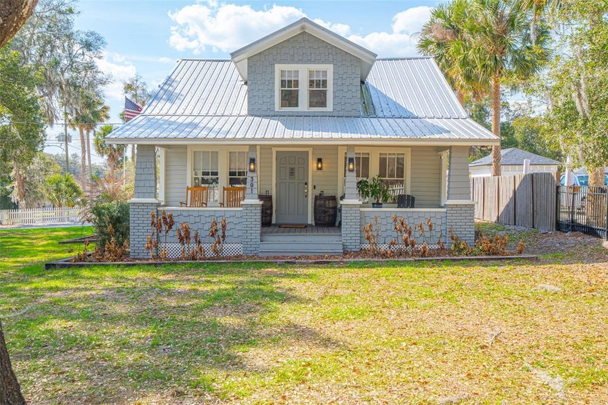 Welcome to a rare opportunity to own a fully renovated historic 1919 charmer in the heart of Orange City. This turn-key beauty blends timeless character with thoughtful, high-end updates: truly no stone has been left unturned. Perfectly positioned on a .38-acre corner lot and wrapped in a classic white wooden picket fence, this home offers storybook curb appeal paired with modern functionality. Inside, you’ll find an inviting open-concept layout where the living, dining, and kitchen spaces flow seamlessly together, ideal for both everyday living and entertaining. The kitchen has been tastefully designed with a gas range, center island, and dedicated eat-in space, creating the perfect gathering spot. The primary bedroom is conveniently located on the main floor and features a beautifully updated ensuite bathroom, with the washer and dryer just down the hall for added ease. A downstairs office with a window and closet offers flexibility as a fourth bedroom, guest room, or work-from-home space. Upstairs, a spacious loft leads to two additional bedrooms and a stunning bathroom complete with a clawfoot tub, separate shower stall, and elegant vanity: a true nod to the home’s historic roots with modern luxury woven in. The main-floor bathroom showcases a beautifully designed walk-in shower and stylish vanity. Outdoor living is just as impressive. Enjoy mornings on the front porch and evenings on the rear porch overlooking the expansive yard. The covered carport offers convenient parking, while the extended gravel area provides additional space for guests, entertaining, or recreational vehicles. The gravel continues to a charming fire pit area: perfect for gathering under the stars, a shed conveniently located just beyond, tucked near the carport for easy access. A durable metal roof adds long-term value and peace of mind. Location is everything, and this home delivers. Walking distance to Orange City City Hall, where local holiday festivities and community events are held, and just minutes to everyday conveniences, shopping, and dining. Quick access to I-4 makes commuting effortless, and you’ll love being centrally located between New Smyrna Beach and Orlando... giving you the best of both coastal relaxation and city excitement. Historic charm. Modern upgrades. Prime location. This home is truly gorgeous and ready for its next chapter. Schedule your private showing today and experience the character, craftsmanship, and convenience of this one-of-a-kind Orange City gem before someone else calls it home.