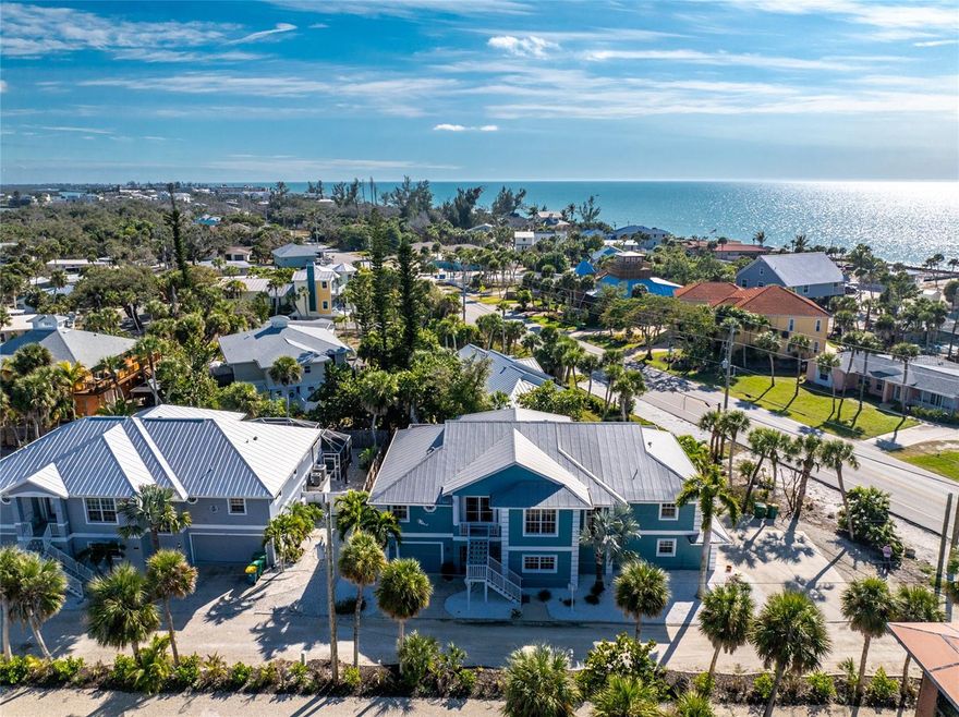 Discover one of Southwest Florida’s hidden gems on Manasota Key! Just steps from both Lemon Bay and the Gulf of Mexico, this fully furnished custom home offers deeded access to both waterways and showcases breathtaking sunsets and serene coastal living. Designed with exceptional attention to detail, the home welcomes you with double-entry glass doors that open to a spacious, open-concept living area featuring cathedral ceilings, abundant natural light, and pocket sliding doors. The expansive 66-foot lanai with composite decking spans the full length of the home, creating seamless indoor-outdoor living ideal for entertaining. The gourmet kitchen is thoughtfully appointed with extensive cabinetry featuring pull-outs, granite countertops, bar-top seating, and a charming breakfast nook. A 14x14 formal dining area provides ample space for hosting gatherings. The split-floor plan offers a private primary suite with three large closets, crown molding, a tray ceiling, and sliding glass doors leading to the lanai. The en-suite bathroom includes a garden tub, dual vanities, and a walk-in tiled shower with glass enclosure. On the opposite side of the home are two generously sized guest bedrooms and a second bathroom featuring a large walk-in shower with a rain shower head. Additional highlights include Hunter Douglas window treatments, porcelain tile flooring, updated lighting, crown molding, smart door locks, a security system, hurricane shutters, and a convenient dumbwaiter servicing the second floor. The first level offers substantial additional air-conditioned space along with an expansive covered lanai. Two separate garages accommodate up to three vehicles and provide ample storage for golf carts, kayaks, paddleboards, fishing equipment, and beach gear. The tropical, professionally landscaped yard is maintained by a private well-fed sprinkler system. Offered fully furnished, this exceptional property is ideal as a full-time residence, vacation retreat, or investment opportunity. A must-see to truly appreciate its flawless upgrades, stunning views, and prime location—just minutes from dining, boating, and all that Manasota Key has to offer.