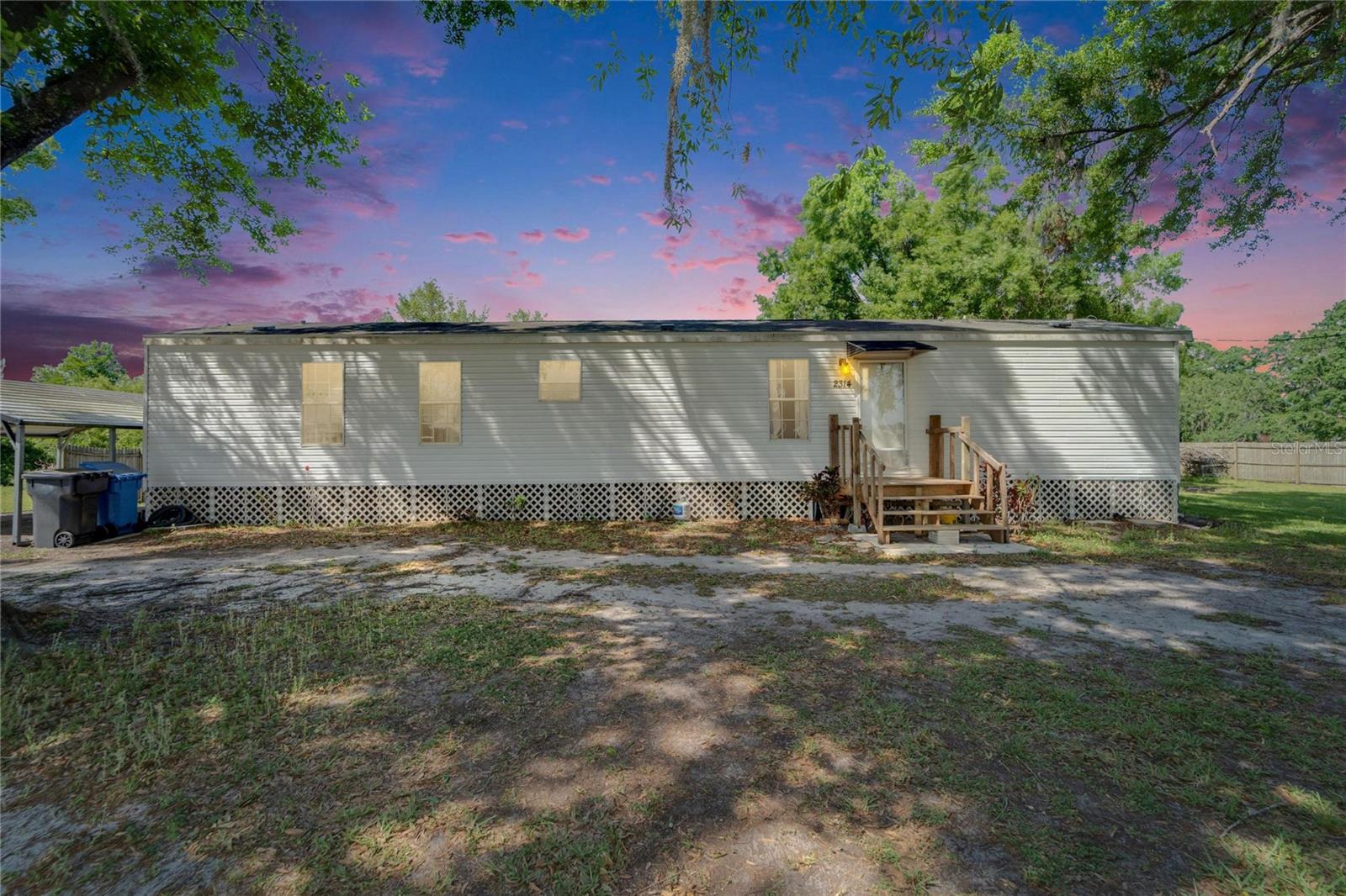 PRICE ADJUSTMENT -Escape to peaceful country living with this inviting 2-bedroom, 2-bath mobile home, ideally set just over an acre. The home offers a spacious open-concept living and dining area and a split-bedroom floor plan that provides added privacy. Just off the kitchen, you'll find a convenient indoor laundry area and a back door leading to a deck ideal for relaxing or enjoying your morning coffee.
From the generous backyard, take in serene pond views, and enjoy the charm of a strawberry field from the oak-shaded front yard. The property also features two storage sheds and a 2 car carport, offering plenty of space for your tools, toys, or hobbies.
Located just minutes from I-4, you'll have a quick and easy commute to Tampa and Lakeland.