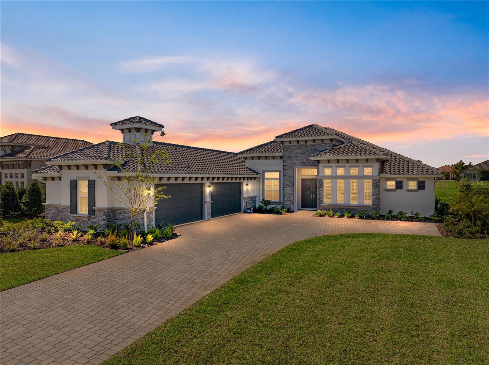 SELLER IS OFFERING UP TO $5,000. towards your LJ Golf Membership, or HOA Fees, or Closing Costs! This exquisite, elegant, and extraordinary, this stunning 2024-built luxury home in the desirable, gated community of Lake Jovita offers the ultimate Florida lifestyle. Perfectly positioned on nearly 3/4 of an acre, the striking exterior makes a lasting impression with manicured landscaping, stone accents, a long paver driveway with extended parking, and an oversized 4-car garage with sealed epoxy floors. A covered double-door entry welcomes you into the grand foyer, where the breathtaking interior unfolds. Soaring 12’ decorative ceilings accent nearly every room, including the foyer, dining, den, living room, kitchen nook, primary suite, and back porch- while long plank tile flooring, dark greige solid-core (6) interior doors, and plantation shutters throughout elevate the aesthetic. The expansive open floor plan is enhanced by prewired TV and internet stations in each room to keep cords hidden and the look seamless. The living room takes center stage, anchored by a statement electric fireplace set against a floor-to-ceiling stone feature wall, flanked by two well-placed floor outlets for flexible furniture placement. The kitchen is nothing short of spectacular, designed to inspire culinary works of art, with thick quartz countertops, an extended island offering wraparound seating for six, a separate ice maker, and glass display cabinets with dimmable lighting framing the beautifully elongated custom hood. Additional luxuries include under-cabinet lighting, pull-out shelving in all lower cabinets, and a hidden walk-in pantry with wooden shelves and outlets for small appliances. An elegant dining room with a tray ceiling offers seamless views of the living space- ideal for entertaining. Nearby, a dedicated office pairs beautifully with a conveniently located half bathroom upgraded with cabinetry, perfect for today’s work-from-home lifestyle. The primary suite is a private retreat with expansive sleeping quarters, two built-out walk-in closets with shelving, drawers, and charging outlets, and two recessed lights over the bed with dimmable switches at each nightstand. The ensuite bathroom is spa-inspired, with gorgeous tiled walls, a serene soaking tub, a custom walk-in shower, dual vanities with vessel sinks and stylish cabinetry, and built-in linen storage. Two guest bedrooms are thoughtfully located on the opposite side of the home, each with a walk-in closet and full ensuite bathroom. One guest bath includes an upgraded layout with an exterior door- perfect for a future pool bath. A full cabinet suite in the laundry room includes quartz countertops, a sink, a shelf over the washer/dryer with valet rods, and sliding shelves in all lower cabinets. An additional laundry sink in the garage and a second washer/dryer hookup add versatility. Other thoughtful touches include prewiring for patio ceiling fans, soffit outlets for Christmas lights, and enhanced recessed lighting throughout. Authentic Florida living awaits outdoors, where a covered porch- already plumbed for a summer kitchen- overlooks the expansive backyard, offering the ideal space to relax or entertain. Beyond the property, Lake Jovita provides an unparalleled lifestyle with two championship golf courses, a resort-style clubhouse, tennis and pickleball courts, dog parks, a fitness center, a one-third-mile walking and running loop with exercise stations, and more.
