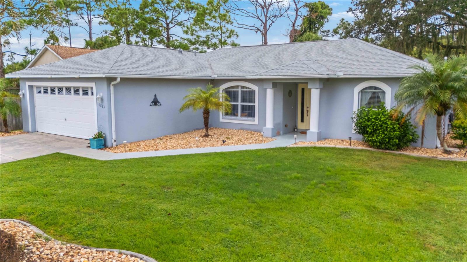 This well-maintained 3-bedroom, 2-bathroom home is nestled on a peaceful road in North Port! Pride of ownership shines throughout, making it truly move-in ready and waiting for its new owner. Inside, the open floor plan is filled with natural light and offers great flexibility. The kitchen includes a cozy eat-in area for a small table, while the spacious living room can be arranged as one large gathering space or divided to create a separate dining area—ideal for adapting to your lifestyle. The primary suite is thoughtfully designed with a large walk-in closet, double vanity, walk-in shower, and linen closet. Two guest bedrooms are situated on the opposite side of the home with a well-appointed bathroom to share. An indoor laundry room adds everyday convenience. Additional highlights include STORM SHUTTERS (2023), ROOF (2019), HVAC (2022), and landscape curbing with rock surrounding the entire home for easy-care curb appeal. Outside, you’ll enjoy a large (20x16) screened-in lanai and a storage shed for extra space. A NEW reverse osmosis system ensures superior water quality, along with a new well pump (2025). The home also features a SimpliSafe security system and is wired for an emergency generator, offering peace of mind and added convenience. This charming home truly has it all—comfort, convenience, and pride of ownership in every corner.
