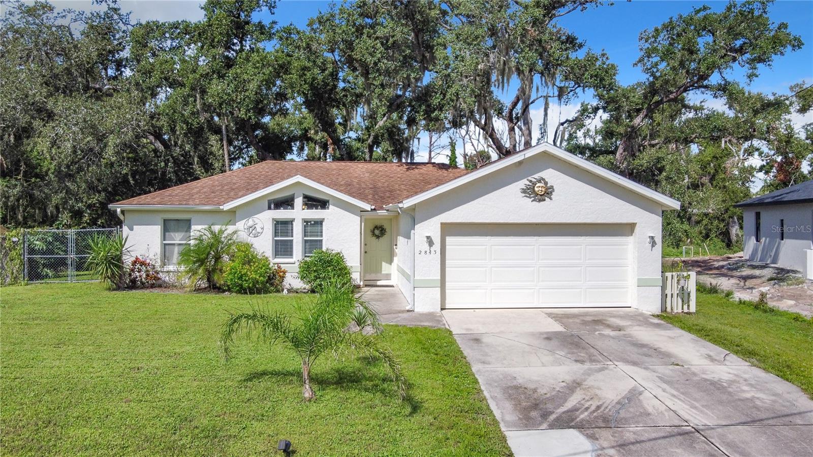 Price adjustment just made this a great VALUE, Welcome! Live BIG in this almost 1300 square foot home that functions much larger! The split plan is separated by the living, dining, and kitchen area. With 3 bedrooms, 2 bathrooms, and a spacious 2 car garage, you have room for everything you need. The open plan with cathedral ceilings adds to the spacious feeling. As you enter the front door you can see the inviting back yard with lush greenery, the view gives the space a certain serenity. The fully fenced back yard is handy for pets and has room for a pool or a big garden. The options are endless consider it your blank canvas. A deck is in place, and connected to the screened lanai, so a sudden shower would not disrupt any BBQ plans. Indoor space is highly functioning, the primary bedroom boasts a walk-in closet and ensuite bath. The guest bedrooms area is divided by a full guest bath. The kitchen has good counter space with plenty of room to prepare meals and snacks. Friends and family will love to gather in the dining area or great room. Updates include a newer roof and water heater. Many dining and shopping options are close by. Golf or pickleball anyone? The courses and courts are too numerous to mention! Also, parks, BEACHES, fishing spots, you will have so much fun trying to decide. Spring training fans will be thrilled to be so close to CoolToday park! It will be easy to cheer on the Atlanta Braves while they are in North Port and the park also holds events and entertainment. Commuters will love the connivence to I75, going North or South is equally easy!
