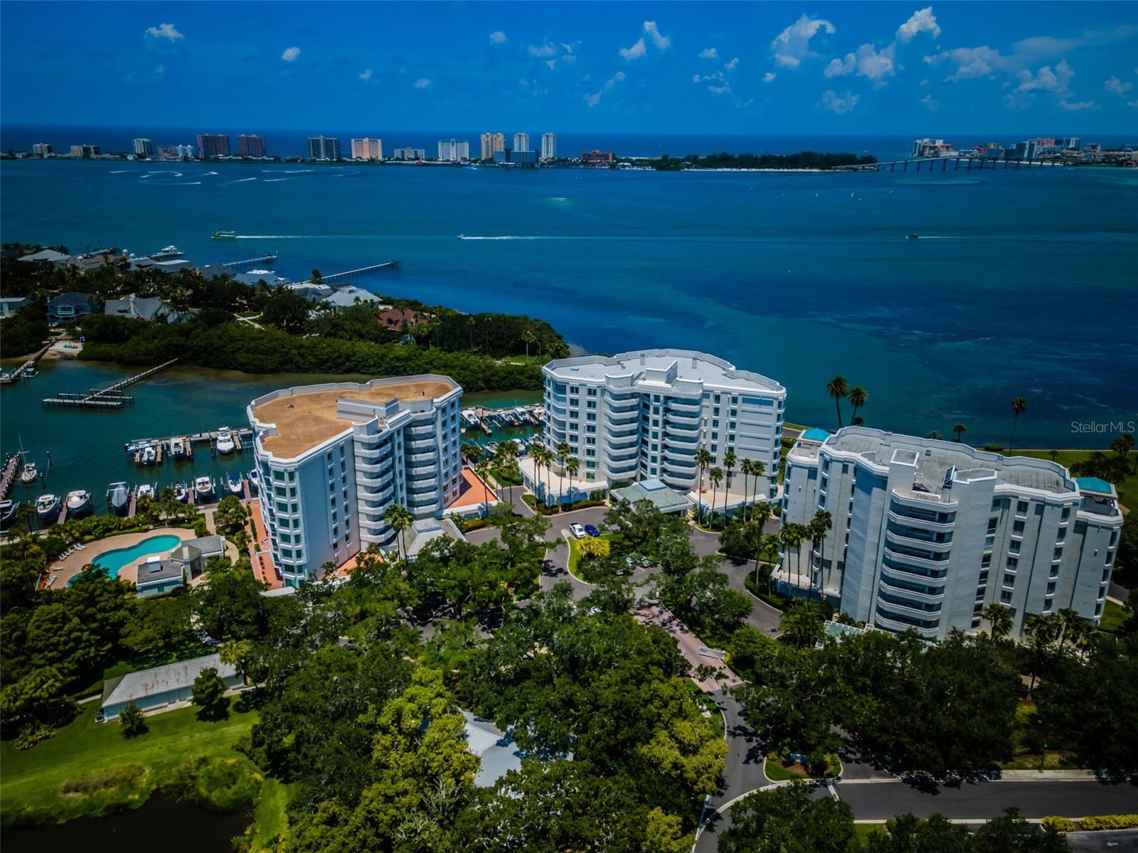 THIS BEAUTIFULLY UPDATED COASTAL CONTEMPORARY LUXURY RESIDENCE DELIVERS SWEEPING OPEN WATER VIEWS OF THE INTRACOASTAL WATERWAY! Located in the highly coveted community of Seaside, and adjacent to the renowned Belleair Country Club and golf course, you’ll love the feel and floorplan of this exceptional condominium with secure and convenient, under-building 2-car parking. Your private gated entrance and exquisite etched-glass double doors transition to a rich foyer and gorgeous panoramic waterviews. This brilliantly-reimagined open-concept unit features large form-factor porcelain floors, stunning new kitchen and baths, radiant modern lighting and electronic window treatments. The sumptuous chef’s kitchen boasts superior quartz surfaces with impressive quartz backsplash areas, lavish designer cabinetry, a fine stainless steel appliance package, a huge island bar/work center and pantry closet. Supported by an elegant matching drybar with wine chiller, your wonderfully-spacious dining area will inspire all with its magnificent water views. The fine living room opens to a fabulous 31ft-wide covered balcony overlooking the intracoastal waterway and the pool deck. The graceful owner’s suite provides terrific water views and opens to the covered balcony; suite includes a separate office/sitting room with its own pool/waterviews. Indulge yourself in the pampering owner’s bath with grand walk-in closet system, posh quartz vanities, coastal white cabinetry, superb dedicated cosmetics center with generous storage, and a luxurious walk-in rainshower with body sprays, body wand and large seating bench. The guest bedroom suite is very large and has a lovely walk-in closet system and a plush full bath with resplendent walk-in glass shower enclosure. You will appreciate the large in-unit multi-purpose storage room and separate laundry room. This residence has a leased 20,000lb boat slip. The community is pet friendly, and offers a heated pool, hot tub, lush mature landscaping and 24-hour gate guard. Bordering the grounds of the Bellevue Inn and the Belleair Country Club, and within minutes of fine dining, shopping and Clearwater Beach, this is a near perfect location to live the Florida dream. Wish to join the Belleair Country Club? By purchasing this unit, you will avoid the years of waiting for a membership. A great value in an outstanding location. Measurements are estimates. Buyer to confirm measurements.