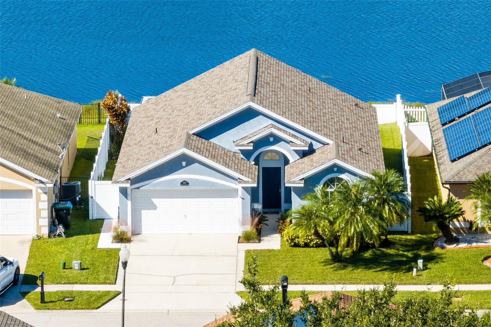One or more photo(s) has been virtually staged. If you're looking for your own little slice of paradise that's also centrally located, THIS ONE IS FOR YOU! This charming 4 bedroom waterfront home in Young Pine feels like vacation! *NEW: Painted cabinets in kitchen & baths 2025, architectural shingle roof 2023, screened porch 2022, vinyl fence 2022* Loaded with curb appeal this home has lush lawn and Florida friendly landscaping showcasing palm trees plus extended width of driveway to allow more parking space, pretty blue exterior, and shaded walkway leading to covered arched front entry! Home is bright and airy with foyer welcoming you to spacious living room with vaulted ceiling, large display shelf and ceiling fan! Sunny kitchen boasts white cabinets, recessed lights, closet pantry, eat-in space, along with newer stainless steel appliances (Samsung twin cooling refrigerator with beverage center in door 2023, LG microwave 2023, Frigidaire Gallery induction range 2019 & Frigidaire dishwasher 2019), breakfast bar that opens to dining room with stunning water views! Dining room has laminate floors, modern light fixture and sliding glass doors to patio with all the best views in the house! Split floor plan offers lots of privacy with Primary Suite on backside of house getting those gorgeous water views and has a vaulted ceiling, sizable walk-in closet with built-in organizer plus en-suite bath offering tile floor, white cabinet vanity with great counter space, medicine cabinet, modern light fixture and tiled tub/shower combo! Two guest bedrooms near front of house have private hall with linen closet and share neutral guest bath with white cabinet vanity, medicine cabinet, modern light, tile floor & tiled tub/shower combo! Fourth bedroom is perfect for a home office or guest quarters away from secondary bedrooms and has ceiling fan and closet! Imagine having your morning coffee out back on the covered patio taking in the water views or unwinding at the end of the day with your favorite drink or book to the serene backdrop of your backyard! Additional covered patio space perfect for grilling in the shade! Want some room to roam, play or garden? This one has that too with large PVC fully fenced yard! Lovely Young Pine is small community surrounding a pond with only two streets and a community playground that is centrally located with easy access to Curry Ford Rd, Goldenrod Rd, Lake Underhill Rd, the 408, the 417, the 528, schools, parks and endless shopping, dining and entertainment options! Hurry, you want to see this one!