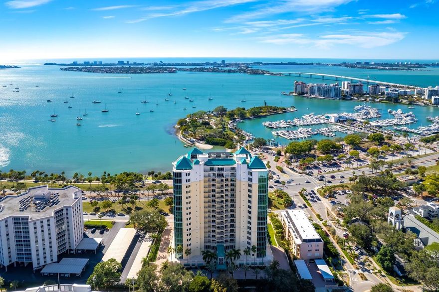 Enjoy unparalleled luxury with scenic bay vistas and resort-like amenities. Welcome to this exceptional residence at the Sarabande Condominium, offering 2,761 square feet of luxurious living with breathtaking panoramic views of Sarasota's iconic Bayfront. After exiting the elevator into the newly remodeled, semi-private entry, you are greeted by a sophisticated open space adorned with warm wood flooring and striking coffered ceilings that create a welcoming and refined atmosphere. The heart of the home is the expansive central living area, where walls of glass frame Sarasota’s stunning shoreline and cityscape. An impressive kitchen features bespoke cabinetry, a beautiful stone-topped island with bar seating, and top-of-the-line Thermador, GE, and Bosch appliances. A wine enthusiast’s dream, the kitchen boasts a 130-bottle wine refrigerator while a water filtration system ensures purity in every glass. Sliders from the kitchen and dining area open onto a spacious balcony, offering stunning views of Sarasota Bay. The primary suite offers an unparalleled retreat with floor-to-ceiling windows showcasing picturesque views, custom built-ins, spacious walk-in closet, and spa-inspired bath with dual vanities and walk-in shower. The guest bedroom also enjoys abundant natural light from large windows, built-in drawers and an en-suite bath, while a generous den provides flexibility as a potential third bedroom with a built-in Murphy bed and desk. Throughout the residence, you’ll find thoughtful design touches, including motion-sensor lights in the custom closets and automated blinds in the living room and primary bedroom. Additional features include a central air purifier, LG washer/dryer (less than 3 years old), and a 50-gallon water heater installed in December 2024. For added convenience, the home offers garage parking for two vehicles, complete with 220V outlet for electric vehicle charging capability, and two storage units with racks. The Sarabande Condominium offers a host of first-class amenities, including pools, spa, fully equipped fitness center with steam room and massage facilities, and a well-appointed club room with a catering kitchen. Residents enjoy concierge service, professional on-site management, and access to guest suites for visitors. Additional amenities include a library, wine storage, and a newly installed roof (2024). The property has also completed its Milestone Inspection Report for peace of mind. Embrace the epitome of refined living in Sarabande.