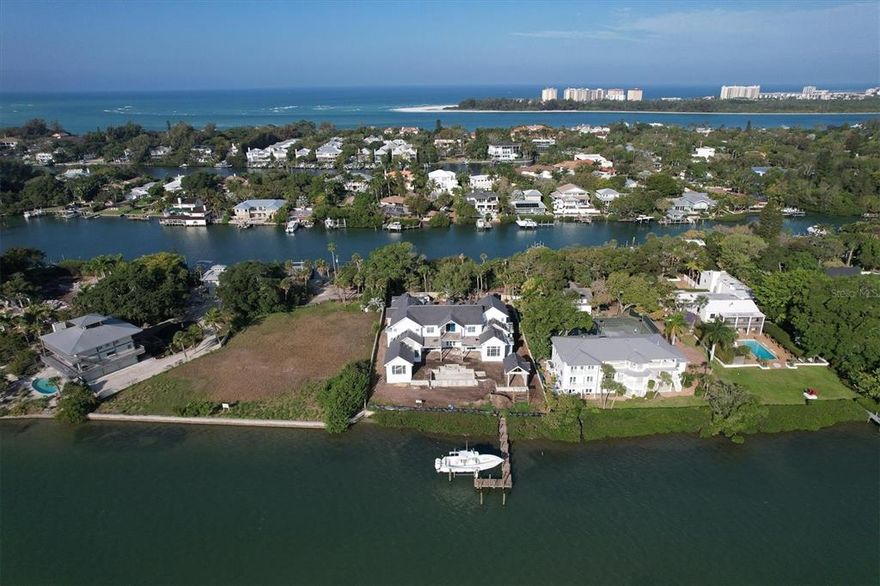 Under Construction. Experience the majestic, private waterfront setting of this dazzling residence on Siesta Key with an approximate completion date of December 2022. Boasting 128’ of water frontage along Roberts Bay, you’ll delight in a tropical backdrop of sea and sky as you savor the island’s resort lifestyle. Built by one of the premiere builders in Sarasota, NC Ferguson Construction, this fully gated home evokes elements of the coast, fusing bay front elegance with beach house style. There’s room for the entire extended family with five bedroom, four baths, and two half baths. Prepare signature dishes in the open kitchen equipped with state-of-the-art appliances and a dreamy layout for either intimate meals or large-scale entertaining. The host in you will love the beautifully detailed formal dining and living rooms. Spend time with loved ones in the expansive family room where a wealth of doors create a seamless transition to the impressive pool terrace. A private office is perfect for taking care of the business at hand. Savor relaxing in the downstairs owner’s suite with stunning water views. The outdoor area is a study in waterfront perfection with an infinity edge pool and spa, separate cabana with fireplace, pool bath, outdoor shower, and an expansive terrace where you can enjoy the soft light of the morning sunrise and vibrant hues of evening sunsets. Enjoy the calm of being on the water from the new dock with 16,000lb boat lift with room for additional mooring, and explore beautiful waterways on your boat. A four-car garage and generator complete the picture. Escape from the hustle and bustle of the real world and escape to the charms of Siesta Key, with the nation’s No. 1 rated beach. Sarasota arts, culture, and urban amenities are just a bridge away.