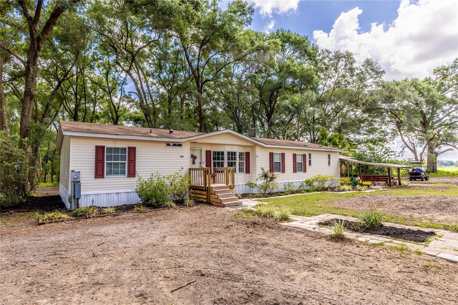 ALMOST 13 ACRES IN OXFORD! Don’t miss this unique opportunity to own a beautifully maintained 3 Bedroom, 2 Bathroom home nestled on nearly 13 fully fenced and gated acres in the heart of Oxford! Boasting approximately 1,716+/- sqft under air, this home offers the perfect blend of privacy, space, and convenience. Inside the home, you’ll find wood-look luxury vinyl plank flooring flowing through the main living areas, including a spacious kitchen and a cozy living room, perfect for relaxing or entertaining. Each of the three bedrooms features plush carpeting, ceiling fans, and ample closet space. This incredible property also includes a large 1,656 sqft pole barn with an additional 640 sqft enclosed area, ideal for storage, a workshop, or future projects. Located just minutes from I-75 and the Florida Turnpike, commuting to Orlando, Tampa, and beyond is a breeze. Plus, you’re only a short drive to The Villages, Publix, Walmart, restaurants, and retail shops. Whether you're looking for a peaceful homestead, room to expand, or a site to build your dream home, the possibilities are endless. Schedule your private showing today and experience the potential this one-of-a-kind property has to offer!