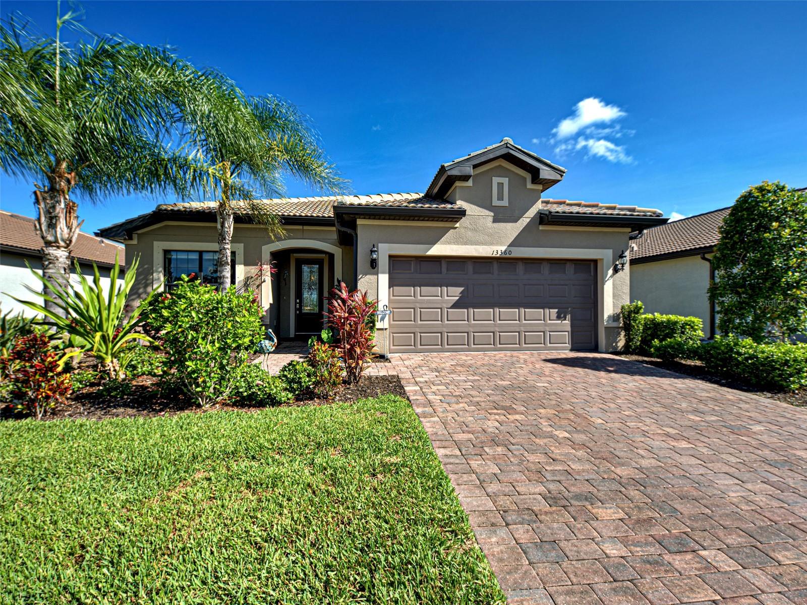 This beautifully appointed Martin Ray model just under 2000 sqft is ideally situated on a premium lot with lovely water views and serene northern exposure in the lanai allowing you to enjoy gorgeous sunrise and sunset views. Designed with both style and functionality in mind, this home features an open floor plan, neutral finishes throughout, tile flooring in the main living areas, 9-foot ceilings, 8-foot doors, and rounded corners that add a soft, elegant touch.
The welcoming foyer leads to a bright flex room, perfect for a home office or creative space. The kitchen features crisp white cabinetry, a spacious Martin Ray signature radius island for casual dining, coordinating backsplash, raised dishwasher for easy access, recessed and pendant lighting, and a spacious walk-in pantry. The adjacent dining area is ideal for entertaining.
Enjoy the tranquil views from the great room, which opens to the covered and screened lanai through a triple sliding glass door. Added sun shades provide extra comfort year-round. The lot offers ample space to add a pool or extend the lanai, maximizing the outdoor lifestyle.
The primary suite features water views, a tray ceiling, luxury vinyl flooring, a large walk-in closet, and a spacious en-suite with a dual vanity, upgraded glass-enclosed shower, and linen storage. A private guest bedroom and bath are tucked away for comfort, convenience and privacy.
The laundry room includes Whirlpool washer and dryer and is centrally located for accessibility.
One of the standout features of this home is the well-equipped garage, complete with epoxy flooring, a utility sink, and a tandem space, perfect for a workshop, golf cart, or extra storage.
This home is located just a short distance from the main resort center, clubhouse, and exclusive resident-only gated back entry to Downtown Wellen Park. Future connectivity to Manasota Beach Road (expected to be done by August 2026) will enhance this home’s already excellent accessibility.
Residing in Islandwalk will give you a sense of resort-style living all year around since it is a very active community with rich amenities including geothermal pools, Har-Tru tennis, pickleball and bocce ball, lap pools, spas, playground, basketball court, a dog park, two State-of-the-Art Fitness Centers, a 24hr staffed front gate, on site 7 day/week HOA staff, outdoor pavillion with BBQ grill, a library and much more that will keep you and your guests active and engaged. Golf carts are permitted throughout the community and can be taken outside Islandwalk throughout Wellen Park when registered. Enjoy exclusive access through a resident-only back gate to Downtown Wellen Park, featuring a Marketplace anchored by Publix, Atlanta Braves ballpark, restaurants. Conveniently located around 4 miles from I-75, offering easy access to multiple pristine Gulf beaches and airports. Historic Venice Island, and cultural events are just a short drive away.