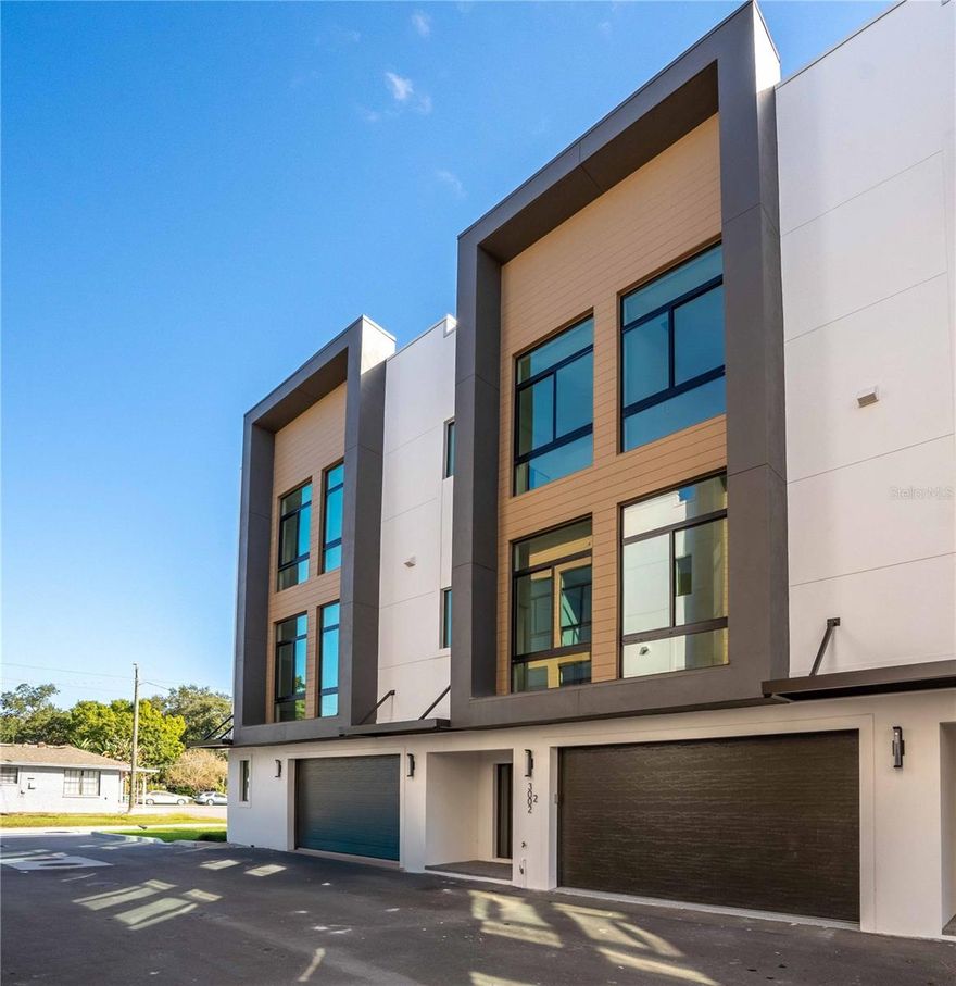 Architecturally striking, modern three-story townhome offering refined urban living in one of South Tampa’s most desirable and walkable locations with 4,300 of total sq ft space. This 4-bedroom, 3.5-bath residence with a 2-car garage delivers exceptional construction quality, thoughtful design, and abundant natural light throughout. Built with ALL block construction, the home is engineered for durability and longevity, complemented by Trane HVAC systems and floor-to-ceiling PGT hurricane-impact windows and doors that provide security, energy efficiency, and a dramatic modern aesthetic. Wide-plank White Oak hardwood flooring flows throughout the living areas, enhancing the clean, contemporary design. The open-concept layout is ideal for both everyday living and entertaining, with balconies on every level and three covered Trex and pavered decks/porches that seamlessly extend the living space outdoors. Natural light pours in from multiple exposures, creating a bright and inviting atmosphere on each floor. The main living level features a private bedroom with a full ensuite bathroom, perfectly suited for multigenerational living, roommates, or students. All bedrooms are equipped with custom closet systems, maximizing storage and functionality. Additional highlights include an epoxy-finished two-car garage, elevator-ready design, guest and street parking availability, and a very low monthly HOA fee—a rare find for new construction in this location. Situated in an X flood zone (no flood insurance required) and zoned for A-rated schools, including Mitchell, Wilson, and Plant, the location is truly exceptional. Enjoy proximity to the University of Tampa, with walking distance access to SoHo, Hyde Park, hospitals, dining, and entertainment, offering the ultimate blend of lifestyle and convenience. A rare opportunity to own a modern, light-filled, and thoughtfully designed townhome in the heart of South Tampa. For More Information, Including Look Books, Association FAQs and Floor Plans, Please Visit the 360 Realty Tampa Website. Builder installing roller shades on Living Room and all Upstairs bedrooms.