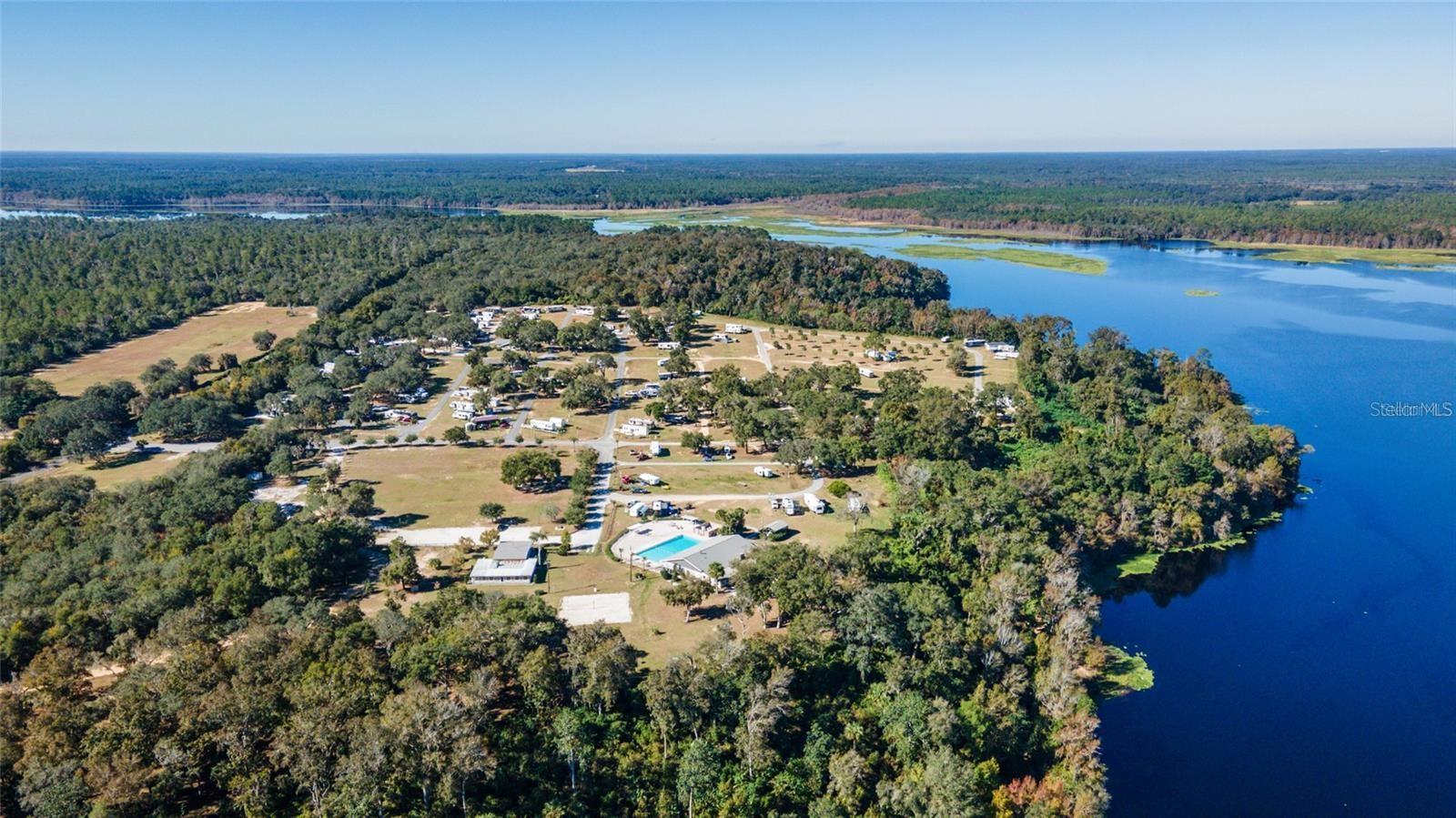 Premium DEEDED LOT property in Oklawaha Overlook Condo with the best views in the neighborhood overlooking Lake Ocklawaha! This RV lot has a concrete pad, paver fire pit area, and is fenced on one side. This property is a great family retreat ~ multi family ~ investment property for AirBnB/Vrbo. Amenities for all ages include a pool, clubhouse, dog park, beach area, playground, corn hole, volleyball, ATV riding trails, nature trails to lake and outlook, and much more. Close to downtown Fort McCoy with grocery store, doctor's office, pharmacy, hardware, gas station, pizza delivery and 30 miles to Ocala's conveniences. For the outdoor enthusiast, lakes, springs, and Ocala National Forest are close by for you to enjoy fishing, hunting, hiking, boating/canoeing/kayaking, and ATV trails! HOA includes electric, water, sewer, trash, and amenities. See attachments for more info. Lot 350 is currently rented for $1,000/month through the park. The 2022 20' Forest River Wolf Pup is for sale for $25k.