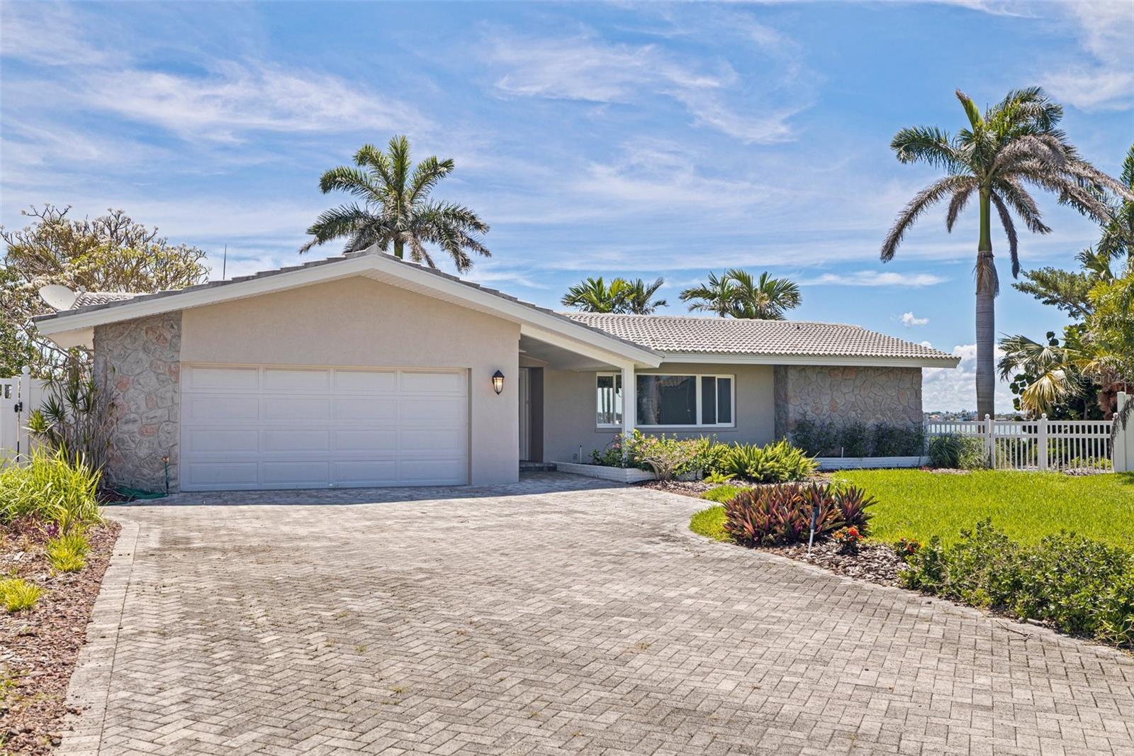 Beautifully landscaped with a long brick paver driveway, this stunning point property presents spectacular open water views across it's sweeping 166 feet of seawall! Beyond its attractive covered entry, step inside this lovely residence and feel the rich welcoming spaces of a fine split bedroom floor plan and its design emphasis on waterfront living. The elegant living area transitions to an open dining space – both with views of the waterfront. The fine, updated contemporary kitchen offers gorgeous water views, exceptional counter surfaces, shaker style cabinetry, striking tile backsplash, stainless steel appliances, unique open built-in wrap-around cabinetry to the living area, and a passthrough to the waterfront lanai. The separate family room opens to the waterfront lanai and has a built-in entertainment center. The Living room/dining, family room and kitchen all have sliding doors/windows that pocket into the
walls, enabling a fantastic indoor-outdoor living environment when desired. Overlooking the waterfront, the owner’s suite contains a sizable walk-in closet and full private bath. The second bedroom is sizable, has private views of the waterway and a spacious walk-in closet. The third bedroom makes for a fine office and has two large walk-in closets. Step out to the 360sqft screen enclosed lanai and take in serene, unforgettable open water views that stretch for a mile across Boca Ciega Bay and the Intracoastal Waterway. Enjoy dazzling days, sparkling nights and the extraordinary marine life found in these remarkable waters. Outside the lanai, you’ll discover wide, expansive and richly manicured grounds with towering Royal Palms, lush subtropical vegetation, meandering brick paver pathways and a fabulous private Zen/meditation garden overlooking the water. Updated dock has a seating bench, fish cleaning station, step down platform for kayaks/paddleboards and a 10,000 lb boat lift for fast, easy access to the Gulf of Mexico. You’ll appreciate the hurricane impact windows/sliders and the peace of mind that they provide. Located in one of Tampa Bay’s best boating communities - close to shopping, dining, entertainment and the world class beaches to Treasure Island. This is a rare “point property” opportunity with huge panoramic views that only 166ft of seawall can deliver.