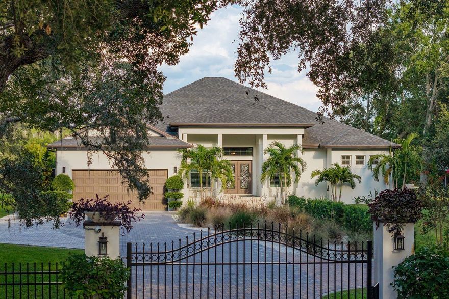 Resort-style living meets modern construction in this stunning 3-bedroom, 3-bath gated pool home with water access, built in 2020 using commercial-grade concrete block construction for lasting durability. Located in a non-HOA community with no rental restrictions, this home offers luxury, flexibility, and convenience—perfect as a primary residence, second home, or investment property.

Step inside through a custom blown glass front door and experience high ceilings, Turkish marble flooring, and an open-concept layout designed for both daily living and entertaining. The chef’s kitchen features granite countertops, a brand new refrigerator and dishwasher, a newer oven, range and microwave, a large center island with an added sink, and an oversized walk-in pantry. A custom dry bar with an aquarium viewing feature adds a unique touch of sophistication and fun.

The spacious owner’s suite includes two oversized walk-in closets with custom closet systems and a luxurious en-suite bathroom with modern cultured stone finishes and a hidden walk-through his and her shower. The suite also includes custom wall openings for aquarium viewing and remote-controlled privacy blinds, offering a perfect blend of relaxation and elegance.

Massive hurricane-impact tri-folding sliding glass doors open to your backyard retreat, where a fully enclosed saltwater pool and screened lanai create a true private oasis. The pool area is equipped with a bamboo plank ceiling, new recessed lighting, new ceiling fans, a 2025 outdoor kitchen, and a perimeter bug spray system. A new pool pump and heater have been installed, offering worry-free enjoyment.  A custom stone privacy wall with built-in fireplaces enhances the ambiance and makes this home ideal for entertaining or enjoying your own peaceful resort-like setting.

Additional features include a whole-house audio system, camera system,  whole-home water filtration and softener system, a roof-mounted cell phone booster, internet booster, beautifully redone landscaping, with upgraded lighting. The garage has been upgraded with brand new epoxy floors, custom cabinetry, overhead storage, and a dog wash station—perfect for pet lovers or anyone needing a functional utility space.

This waterfront property offers direct water access with no bridges, making it an ideal location to build a dock or enjoy kayaking and paddleboarding right from your backyard. Mangroves were recently maintained, eliminating that task for the new buyer. The home sits on a large lot with excellent frontage, providing both privacy and curb appeal. Conveniently located just minutes from Tampa International Airport, shopping, dining, and local attractions, this home offers a rare opportunity to enjoy the Florida lifestyle in a luxurious and move-in-ready setting.