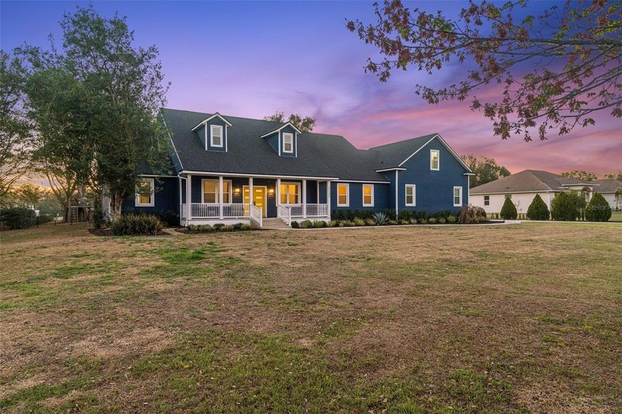 Some homes are simply places to live. Others become the backdrop for unforgettable memories. Set on a beautiful one acre homesite in the peaceful Wolf Branch Village community, this fully renovated residence offers the perfect balance of modern comfort, outdoor freedom, and relaxed Florida living just minutes from the charm of Mount Dora. From the moment you arrive, the home captures attention with its striking deep blue exterior and cheerful yellow front door, creating a warm and inviting first impression that reflects the personality of the property.
Inside, natural light fills the open living spaces, highlighting the clean lines and thoughtful design of this beautifully updated home. The spacious living area flows effortlessly into the heart of the home, a stunning modern kitchen featuring sleek finishes, custom cabinetry, and a large waterfall island that becomes the natural gathering place for family and friends. Step outside and the experience truly begins. The backyard stretches across the entire acre and feels like your own private park. Wide open green space invites games, gatherings, and peaceful afternoons under the shade of mature trees. Evenings naturally come alive around the custom fire pit where friends and family gather under the stars.The outdoor entertaining patio is designed for relaxed Florida living with space for dining, grilling, and unwinding beneath the soft glow of patio lights. Just beyond, a charming elevated treehouse deck nestled among the trees creates the perfect hideaway for kids or a quiet retreat to enjoy the breeze and surrounding nature. The expansive lawn offers endless possibilities for the future. A dream pool, outdoor kitchen, garden, workshop, or recreational space can easily become part of the vision. Inside the home you will find five spacious bedrooms and three bathrooms, offering flexibility for families, guests, or multigenerational living. The bonus room above the garage provides an ideal opportunity for a guest suite, home office, media room, or private retreat. Located just minutes from the 453 connector, commuting to Apopka, Lake Mary, and Orlando is convenient while still enjoying the quiet lifestyle this community provides. The vibrant downtown of Mount Dora is also nearby, known for its lakeside charm, festivals, restaurants, and boutique shopping. Homes that combine modern updates, privacy, acreage, and lifestyle outdoor living are rarely available. This property offers more than a home. It offers space to breathe, gather, and truly enjoy where you live.