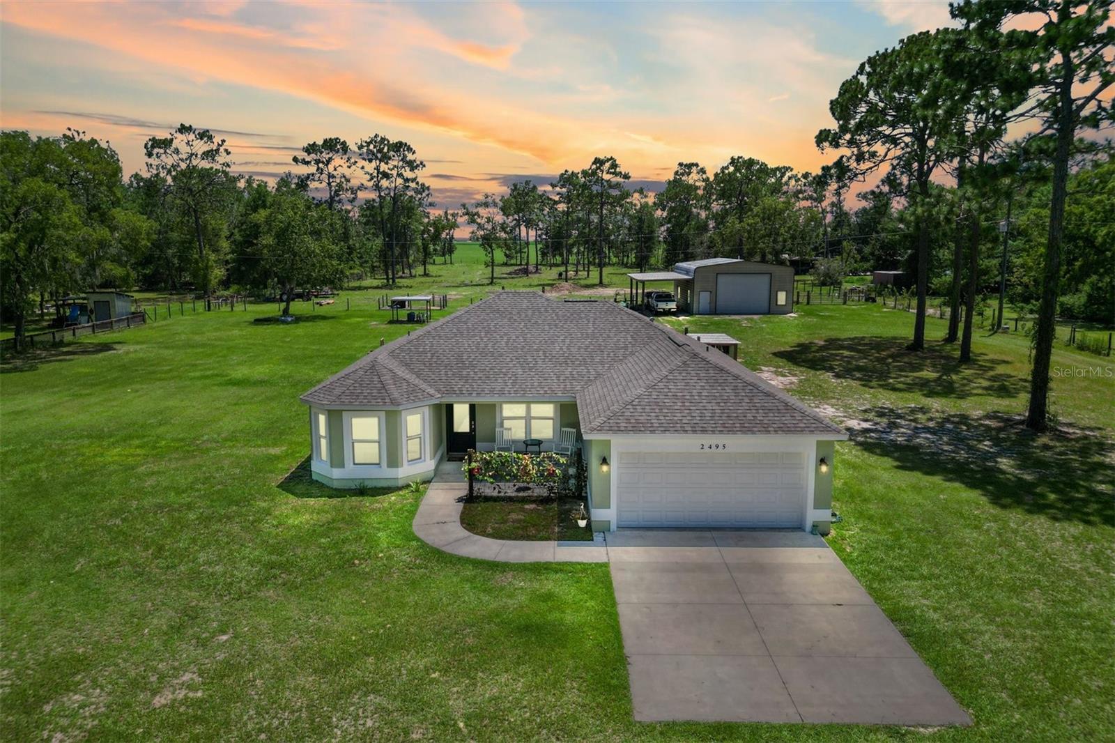 Escape to peace and privacy with this modern farmhouse retreat in Oxford, FL, built in 2022 and nestled on just over 5 acres of land. Tucked away in a quiet setting, this property offers the perfect blend of style, comfort, and functionality with endless possibilities for how you choose to enjoy it.
Step inside to find a thoughtfully designed home featuring luxury vinyl plank flooring throughout the main living areas with cozy carpet in the bedrooms. The open-concept kitchen is ideal for entertaining, showcasing elegant quartz countertops in both the kitchen and bathrooms for a sleek, modern finish. The inviting covered front porch welcomes you in, while the rear screened lanai and concrete grilling patio provide the perfect spaces for gathering with family and friends.
The land is yours to enjoy—whether you envision farm animals, gardens, or simply open space to roam, you have the freedom to create your own lifestyle. A 40'x30' barn on the property expands the opportunities even further, complete with a full bathroom for convenience. The barn can serve as a workshop, storage space, or a place to house your outdoor toys like boats and ATVs. An attached carport provides covered parking for one vehicle.
For added peace of mind, the property is gated, offering both privacy and security.
This is more than just a home—it’s a lifestyle. A rare opportunity to own a modern farmhouse on acreage in a sought-after Oxford location, just minutes from The Villages and all the surrounding conveniences.
Schedule your private showing today and make this opportunity yours!